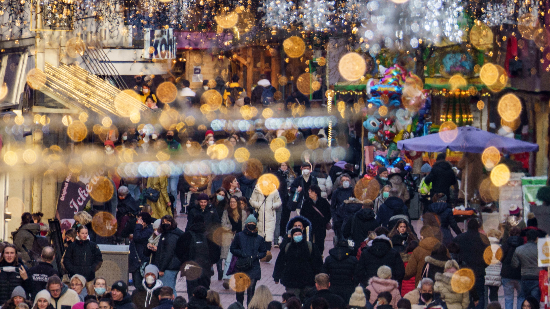 Menschen laufen im Dezember 2021 teils mit Corona-Maske durch eine Einkaufsstraße in Gießen. | dpa