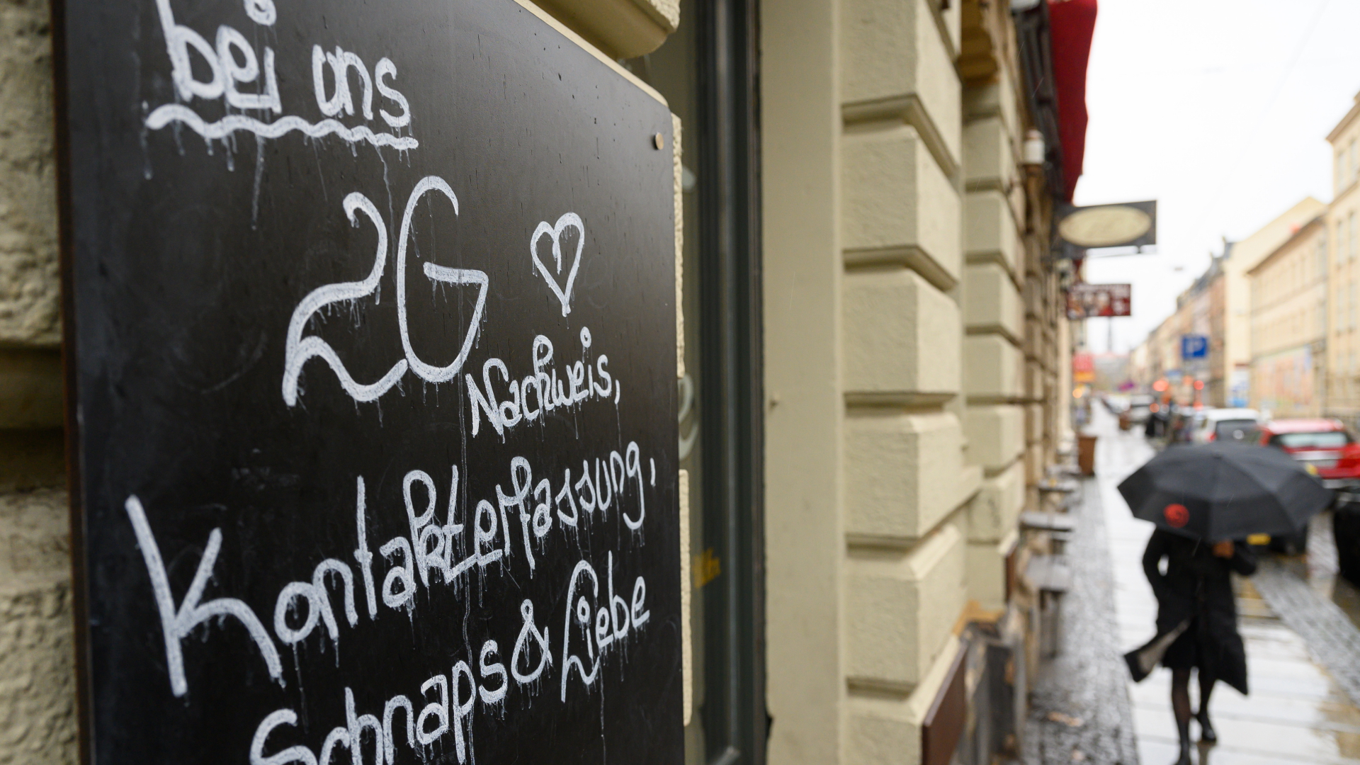 : "Bei uns 2G Nachweis, Kontakterfassung, Schnaps & Liebe" steht auf einem Schild an einer Bar in der Dresdner Neustadt