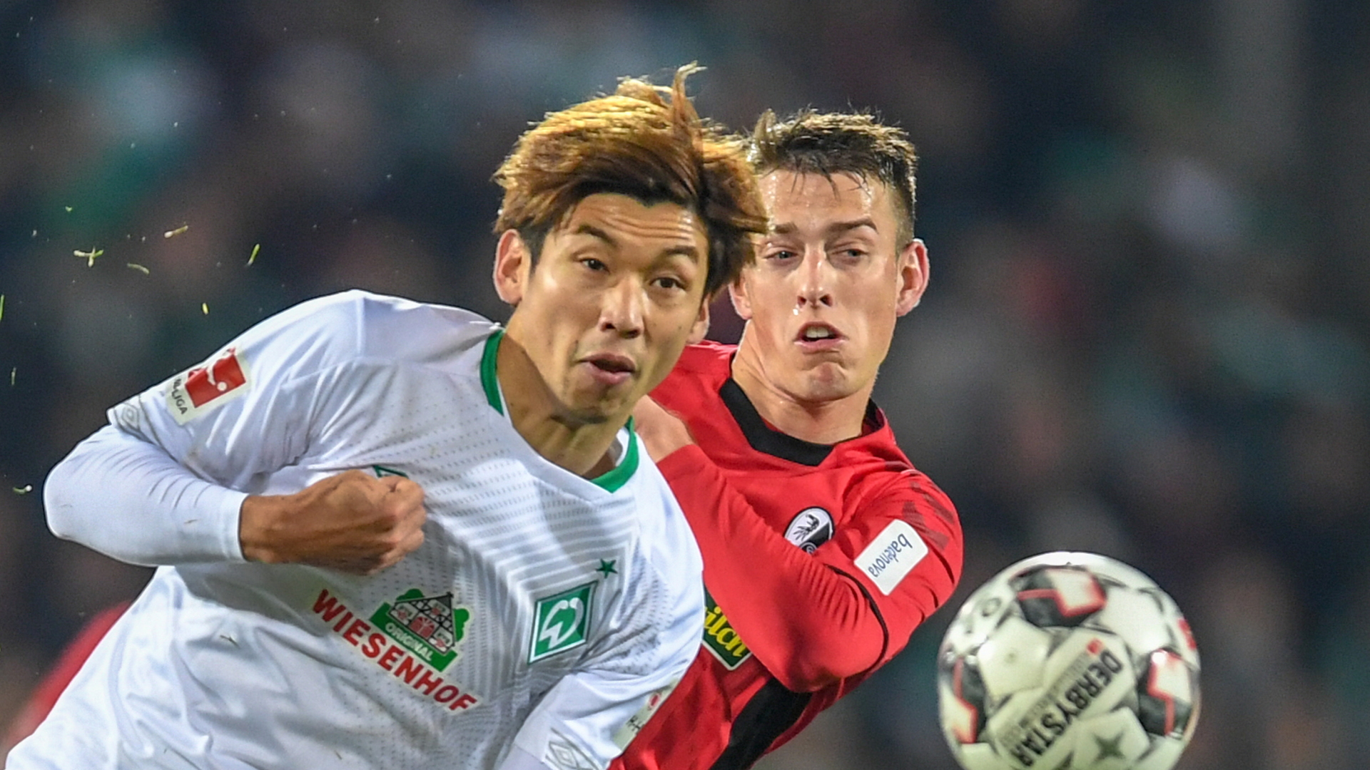 Janik Haberer von Freiburg und Yuya Osako von Bremen kämpfen um den Ball. | Bildquelle: dpa