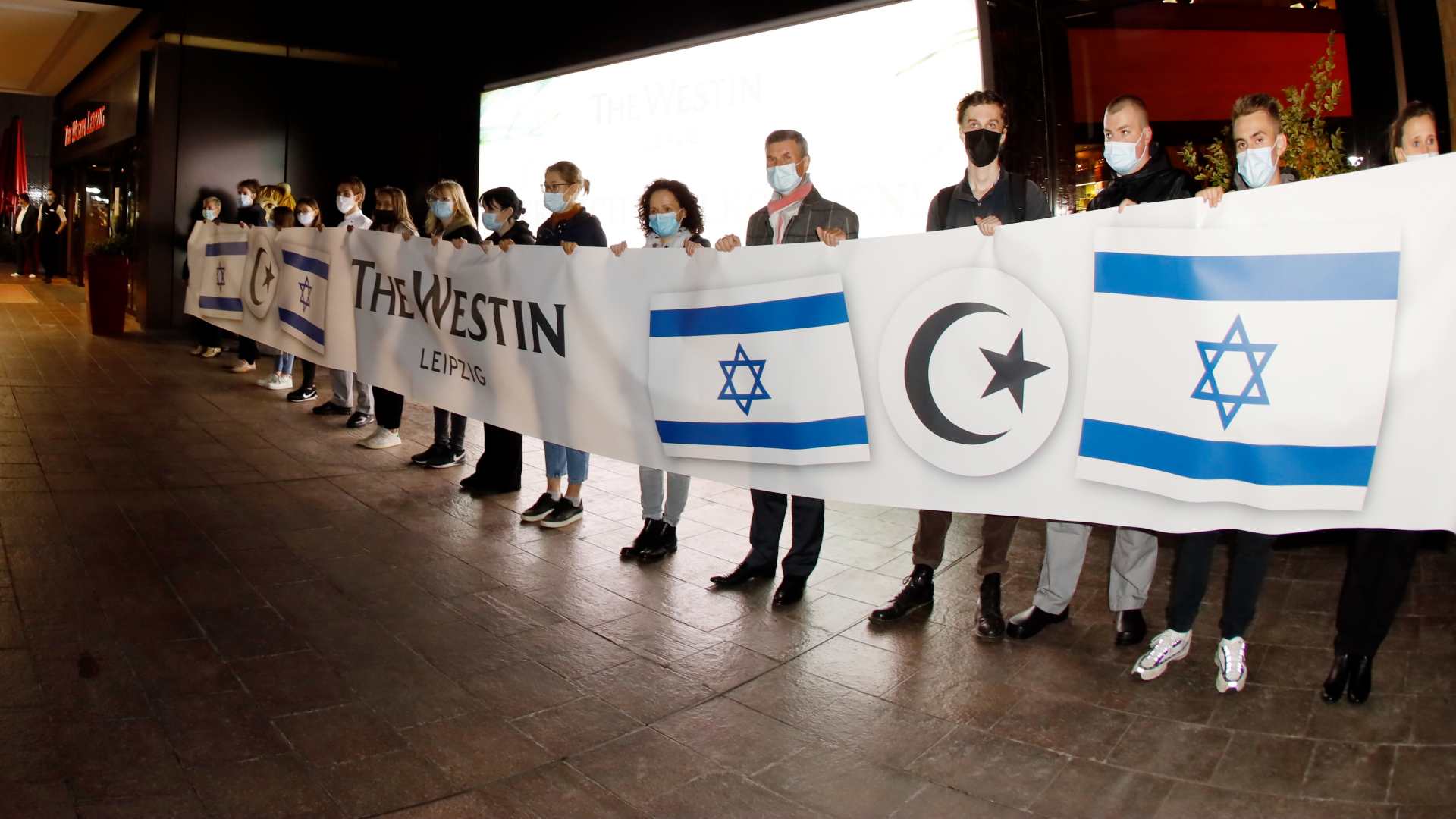 Mitarbeiter mit einem Banner vor dem Westin-Hotel in Leipzig | dpa