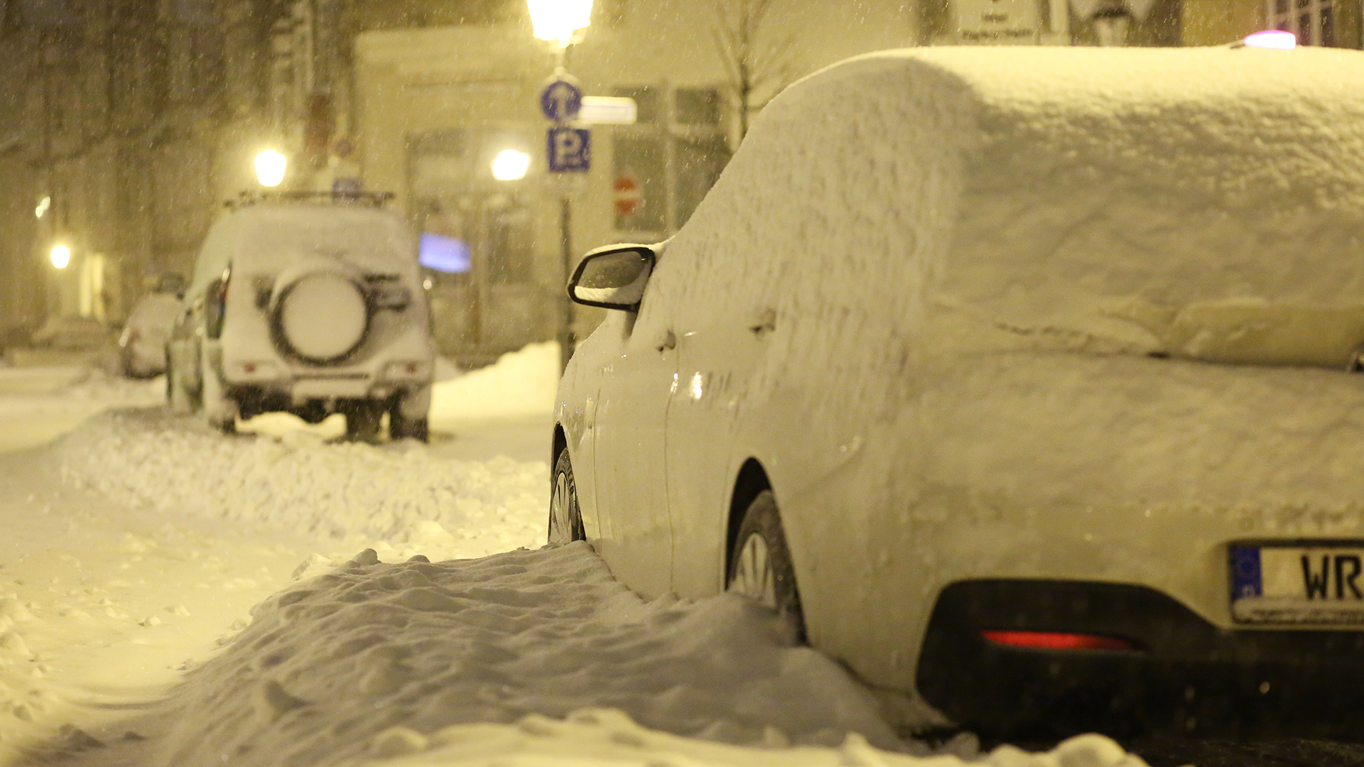 Sachsen-Anhalt, Wernigerode: Schnee bedeckt am frühen Morgen eine Straße und die dort parkenden Autos. | dpa