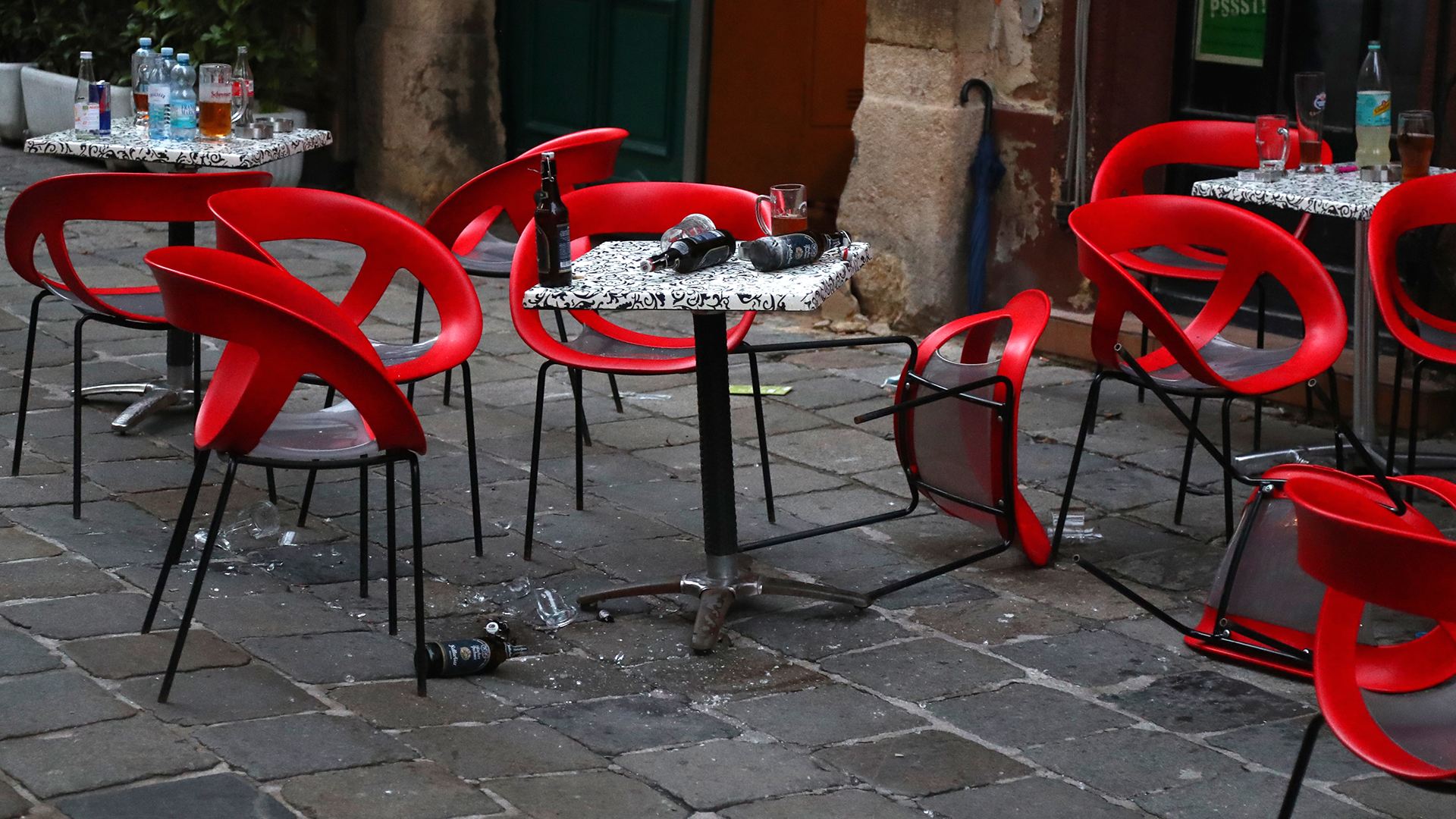 Stühle und Scherben liegen im Bereich des Tatorts einer Terror-Attacke vor einem Restaurant auf dem Boden.  | dpa