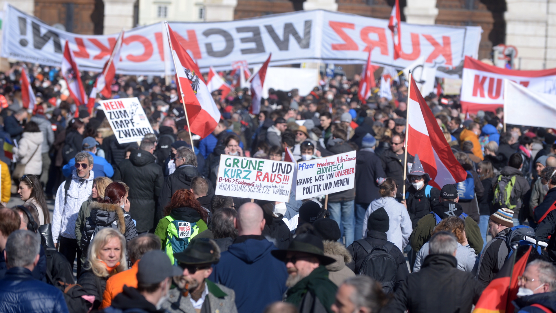 Demonstrierende stehen ohne Masken dicht an dicht und halten bei einer Kundgebung gegen die Corona-Maßnahmen der österreichischen Bundesregierung Schilder in die Höhe. | dpa