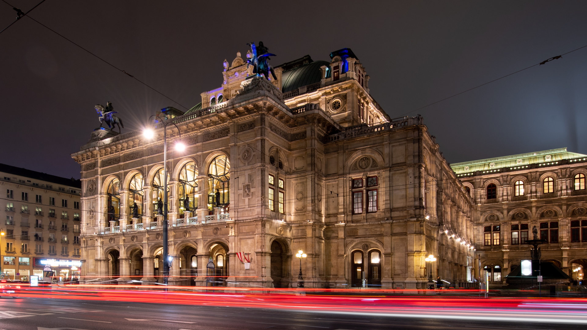 Die Lichter vorbeifahrender Autos sind vor der Wiener Staatsoper zu sehen. (Archivbild) | dpa
