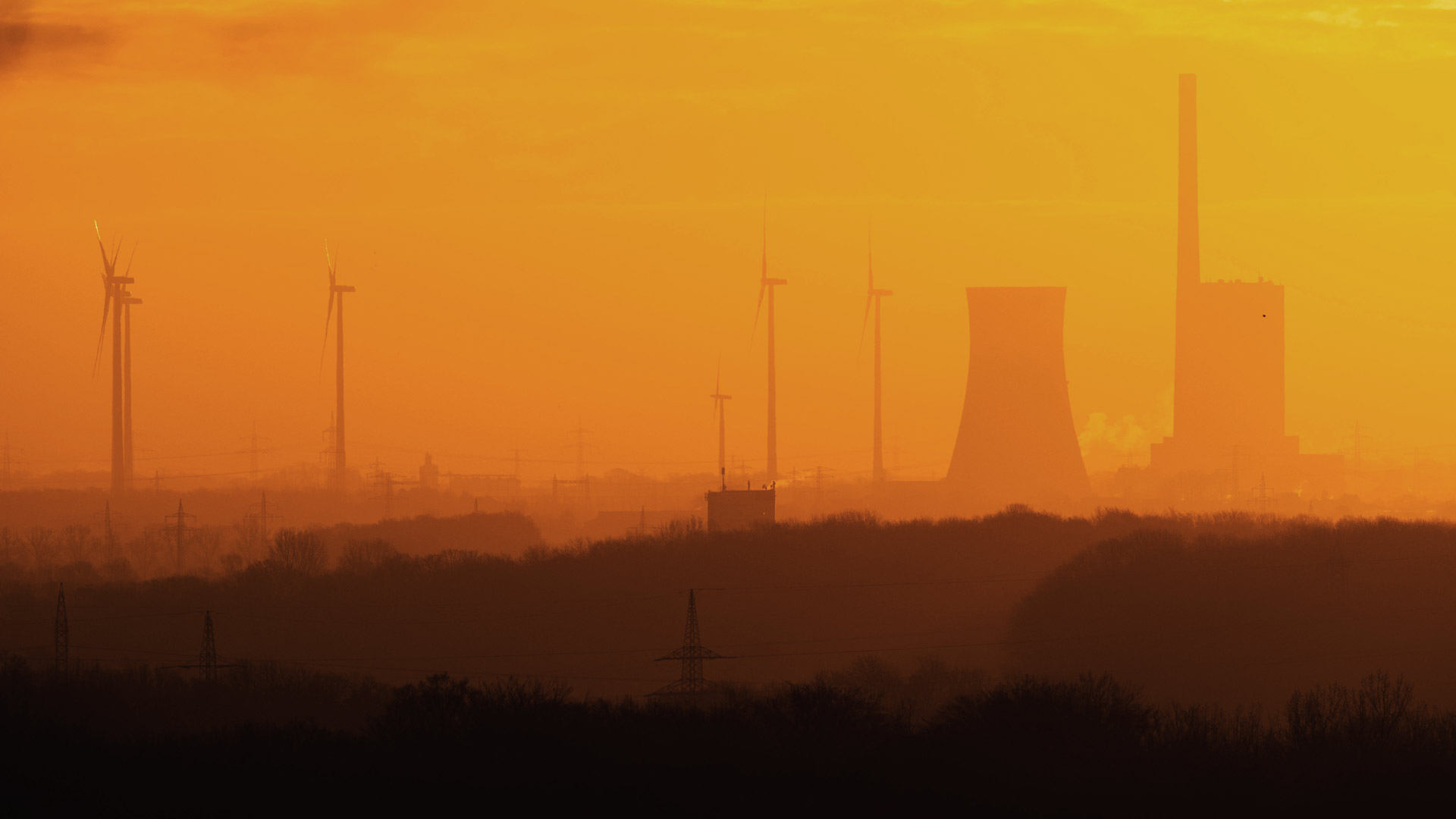 Kohlekraftwerk Mehrum und Windkrafträder bei aufgehender Sonne.
