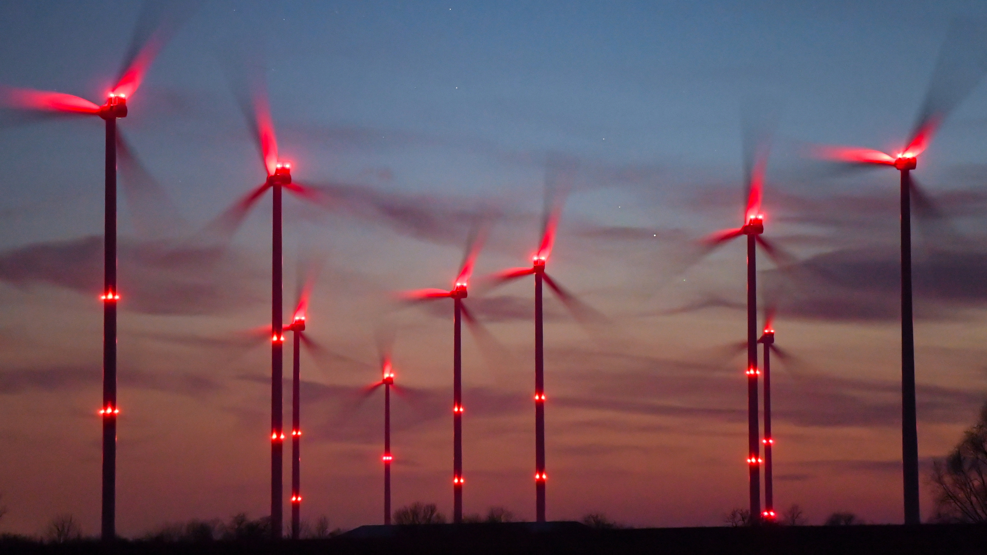 Rote Positionslichter leuchten an Windrädern in einem Windenergiepark | dpa