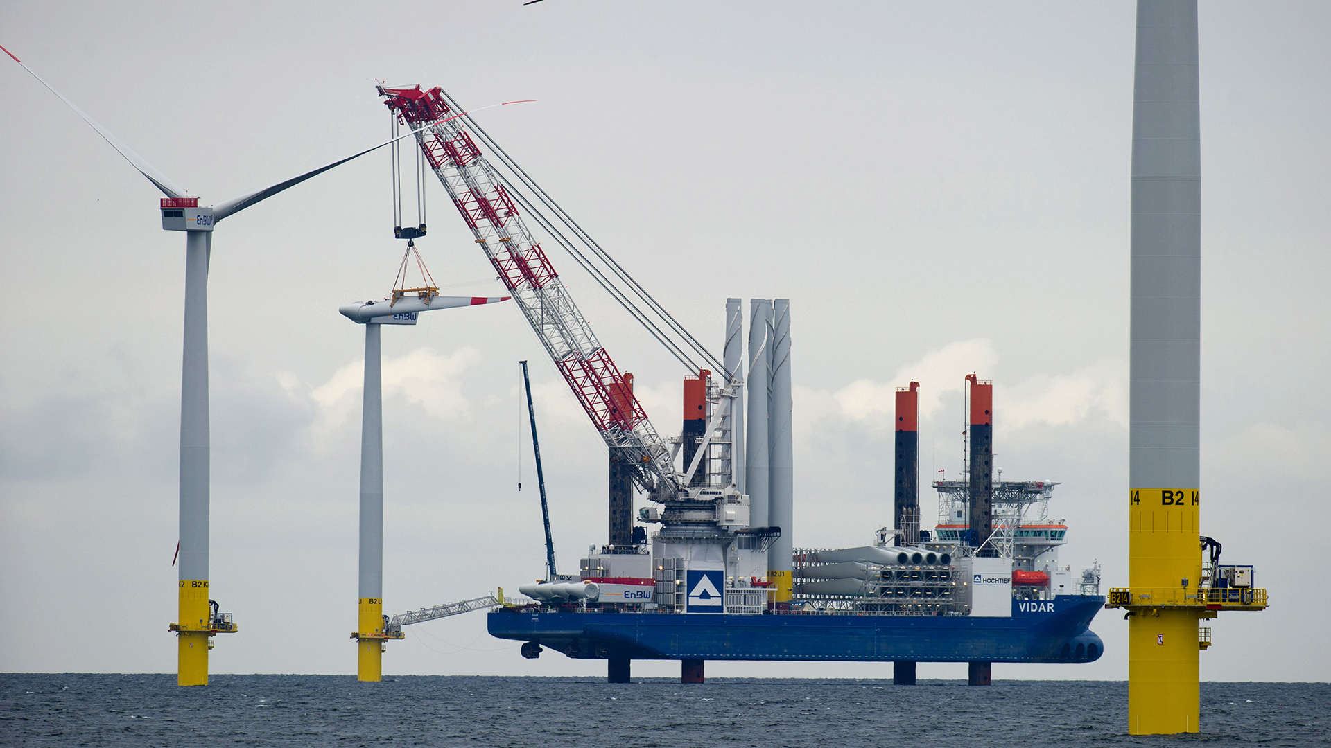 Mit dem Hubschiff "Vidar" wird im Ostsee-Windpark EnBW Baltic 2 auf der Ostsee bei Sassnitz (Mecklenburg-Vorpommern) ein Rotorblatt einer Offshore-Windkraftanlage montiert. | picture alliance / dpa