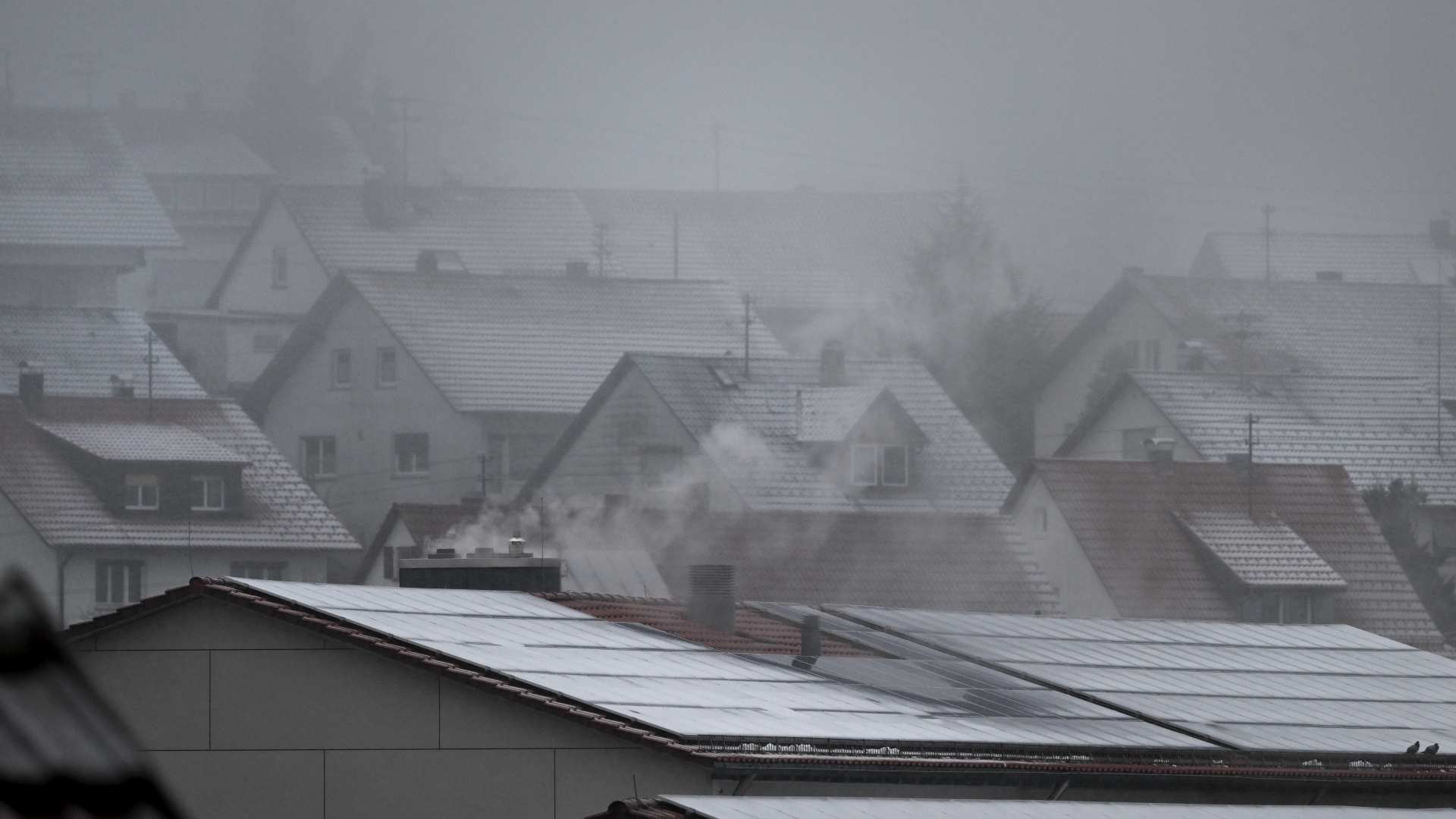 Ein Hauch von Schnee liegt auf Hausdächern 