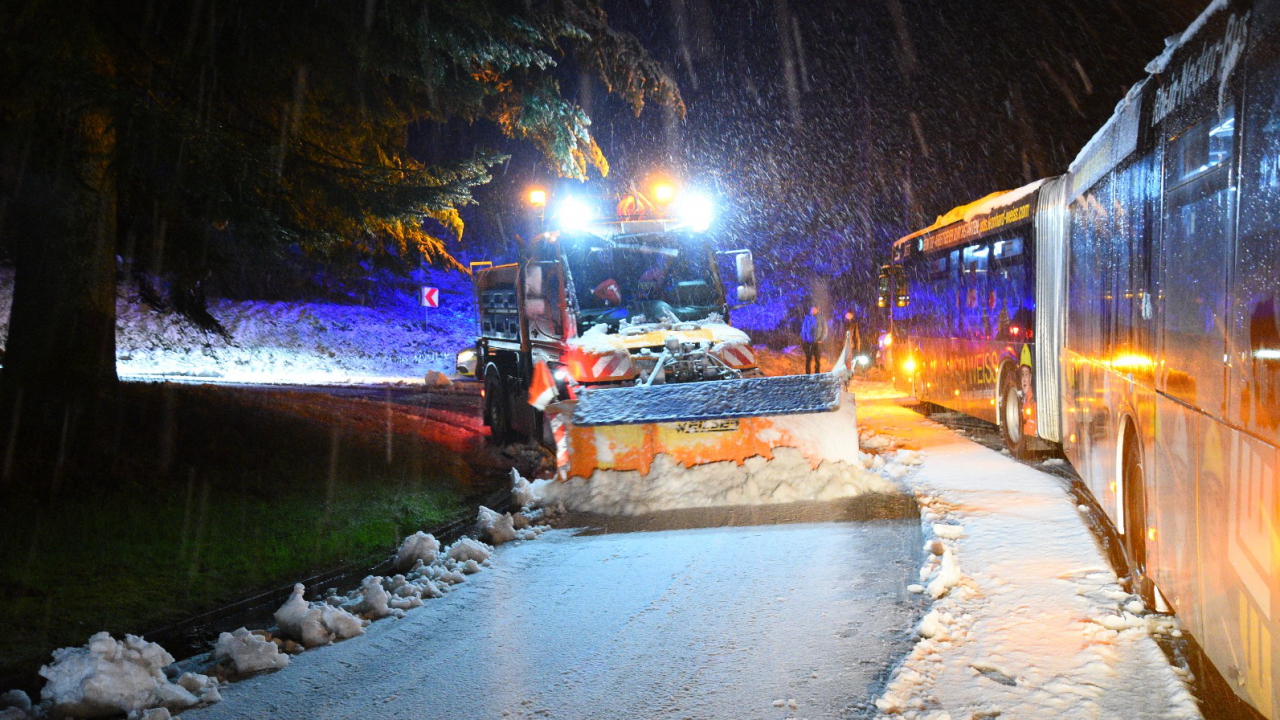 Ein Schneepflug räumt eine verschneite Straße neben einem Linienbus in Baden-Württemberg während eines Wintereinbruchs im April.  | dpa