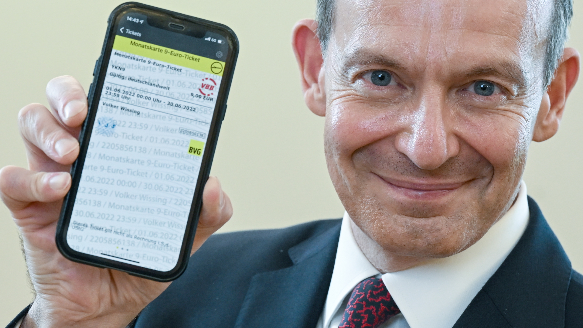 Bundesverkehrsminister Wissing hält sein 9-Euro-Ticket auf dem Handy in die Kamera