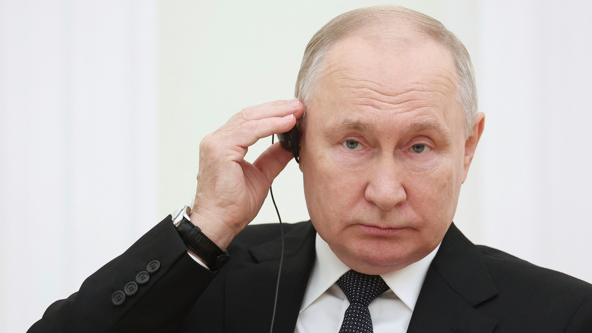 Wladimir Putin trägt einen Kopfhörer.