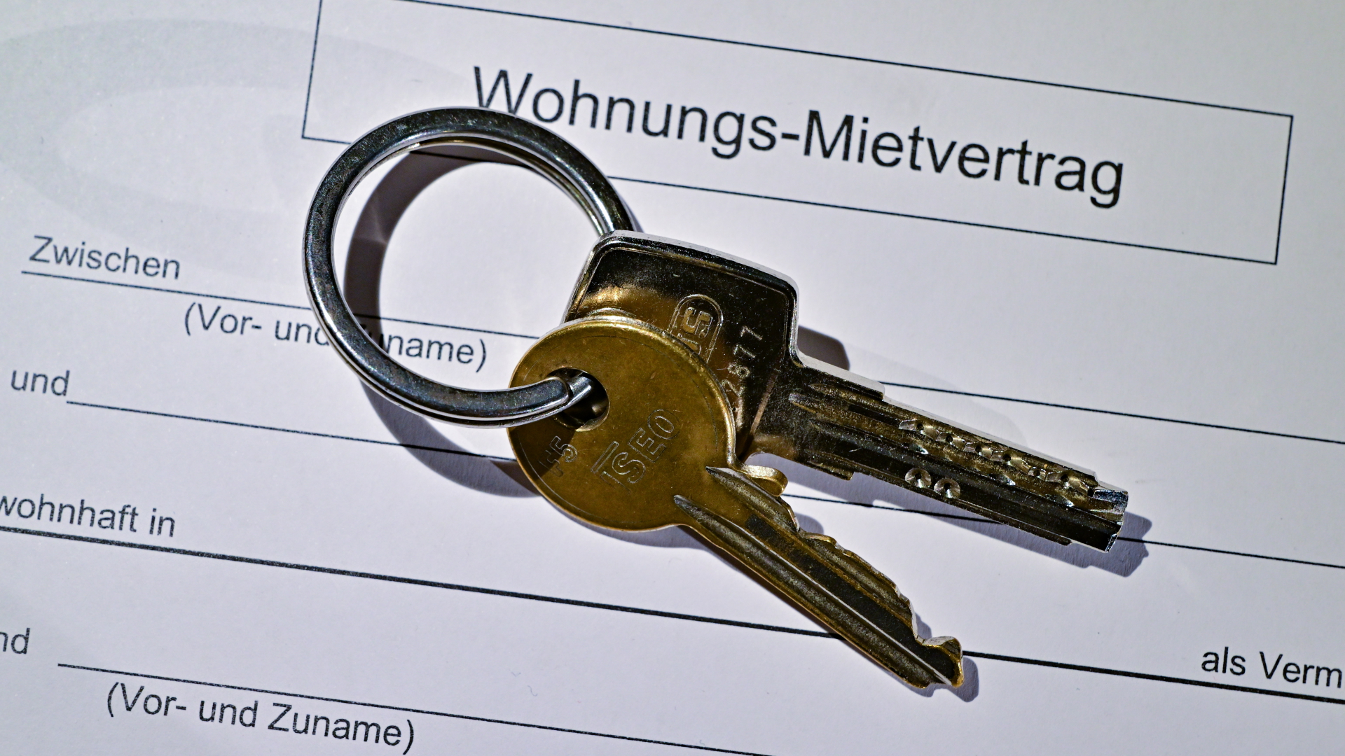 Ein Wohnungsschlüssel liegt auf einem Mietvertrag für eine Wohnung.