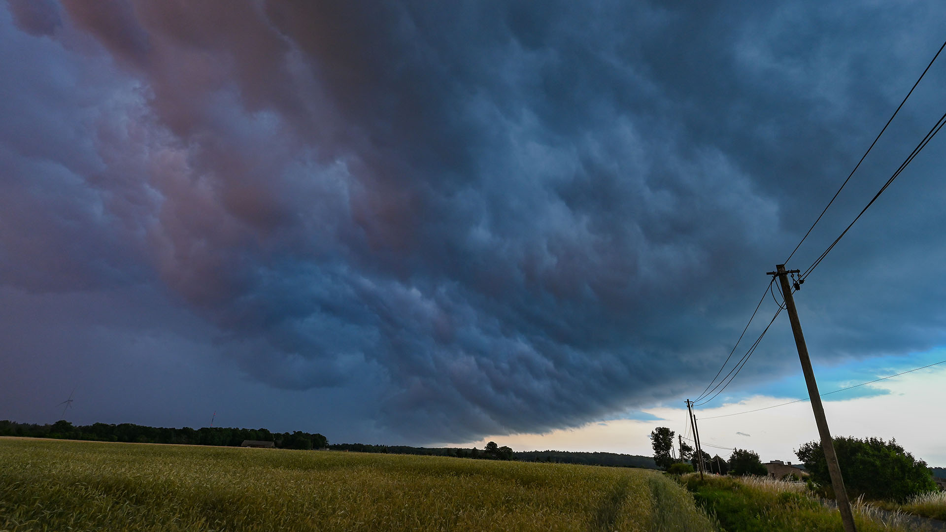 Am späten Abend zieht eine Gewitterzelle mit dunklen Regenwolken über die Landschaft. | picture alliance/dpa