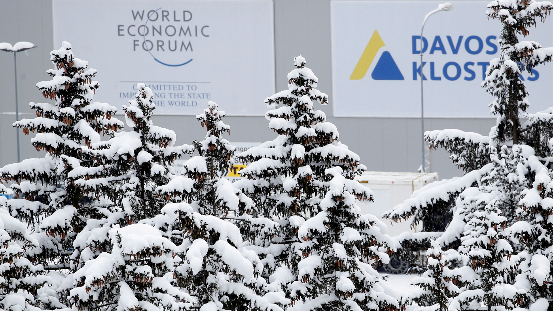  Logo des World-Economic-Forums in Davos und schneebedeckte Tannen. | REUTERS