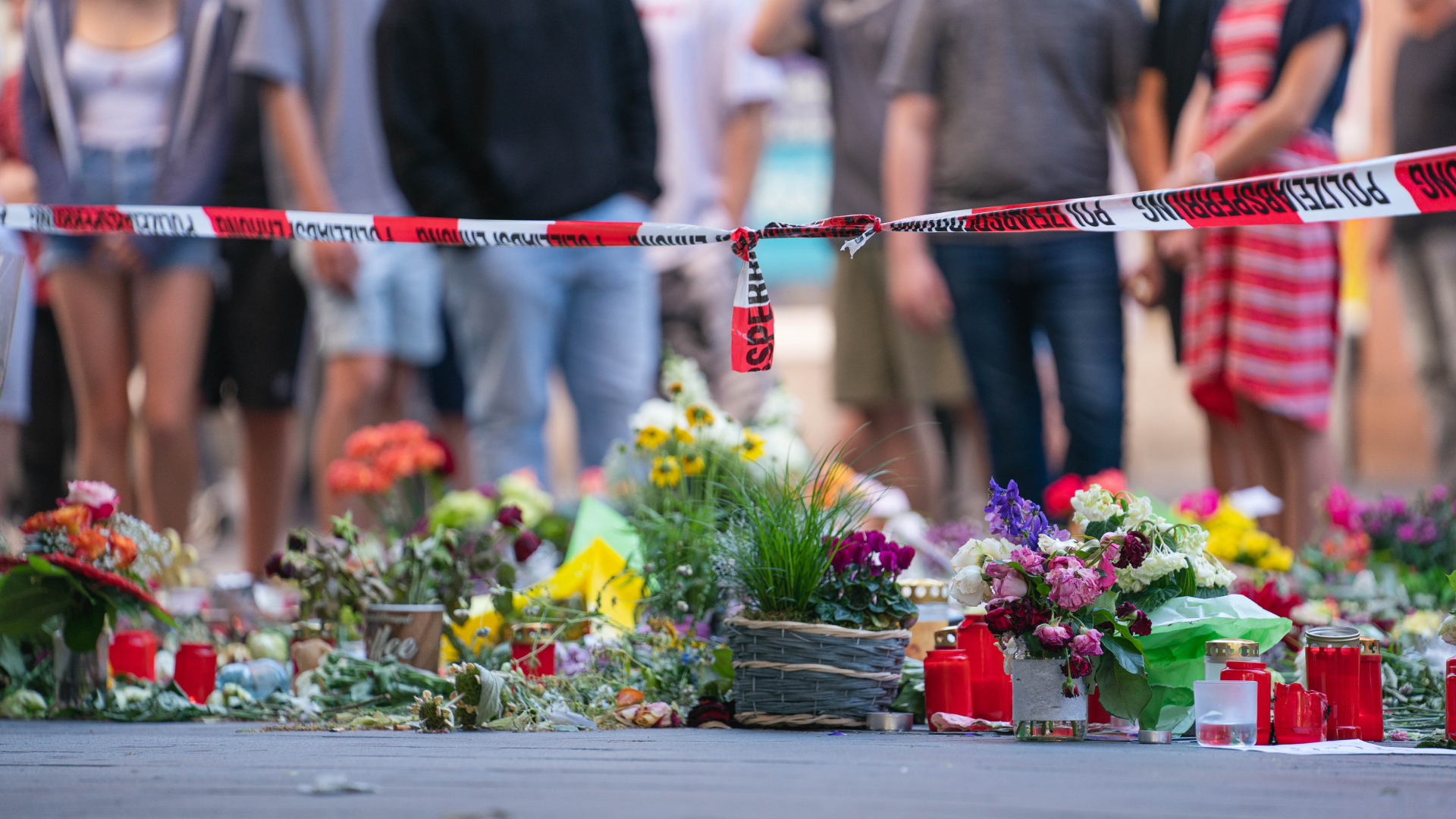 Blumen liegen in der Würzburger Innenstadt am Tatort einer tödlichen Messerattacke im Juni 2021. | dpa