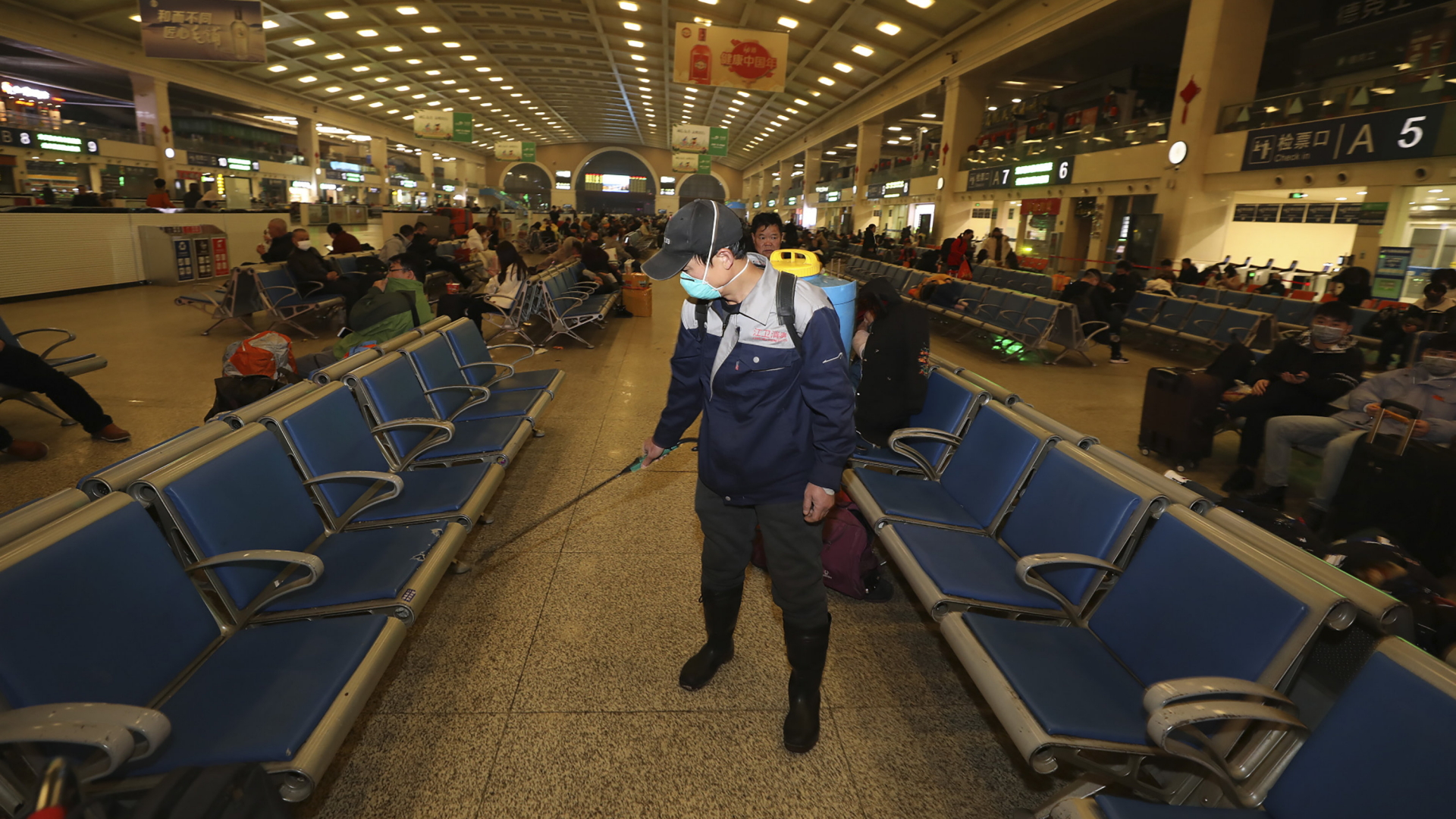 Ein Mann desinfiziert eine Halle an einem Bahnhof von Wuhan. | AP