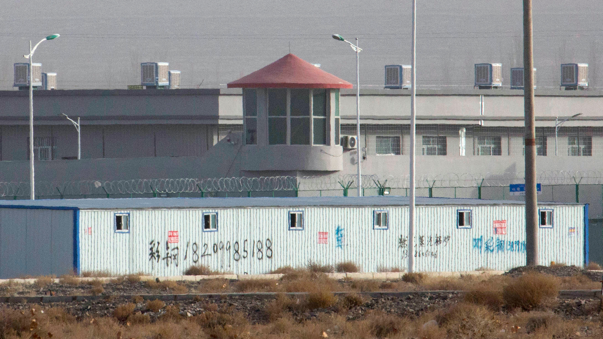 Ein Wachturm und Stacheldrahtzäune sind um eine Anlage in der westchinesischen Region Xinjiang zu sehen.