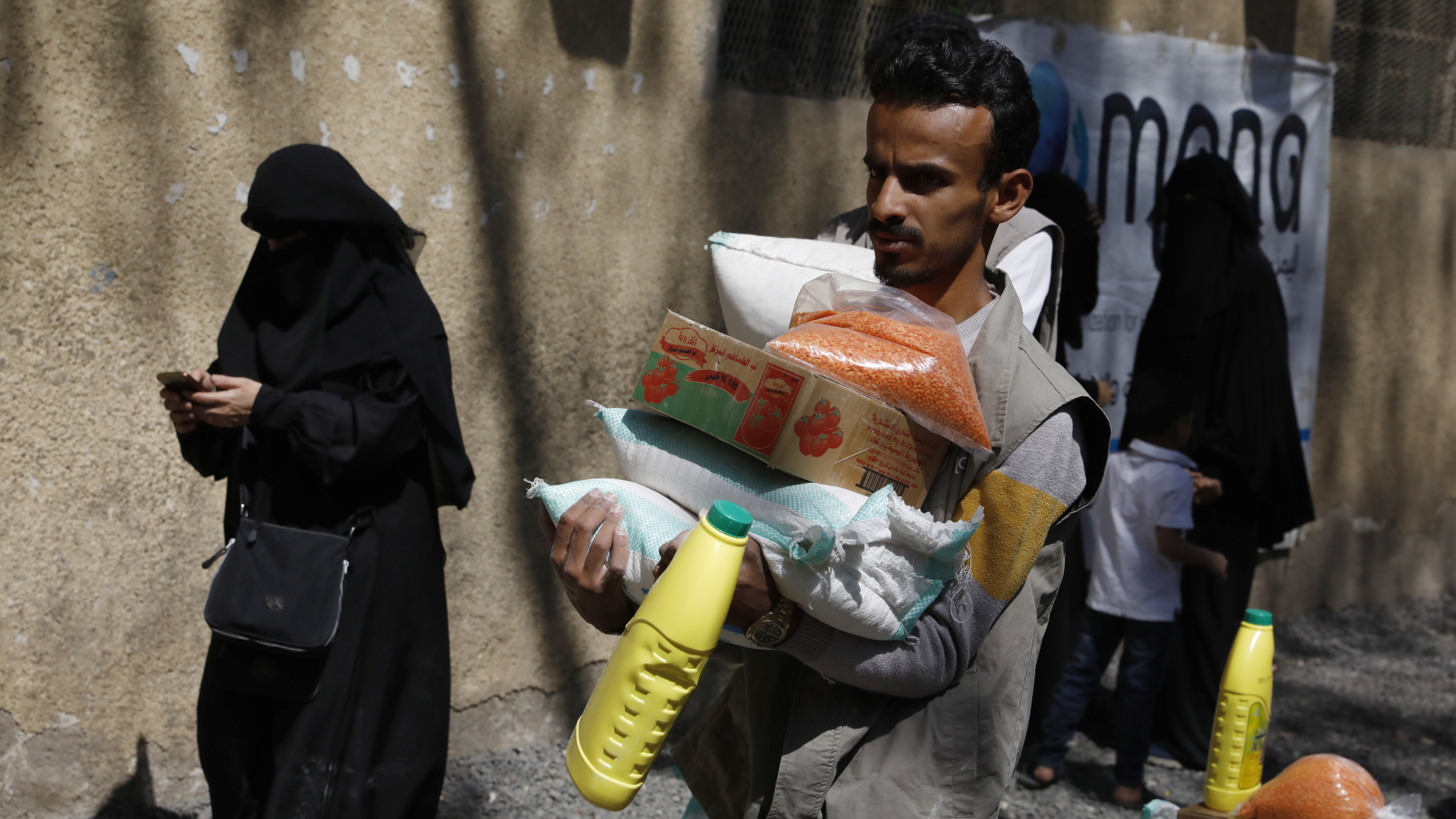 Ein Helfer verteilt Lebensmittelrationen des Hilfswerks Mona an Konfliktopfer in Sanaa, Jemen.  | EPA