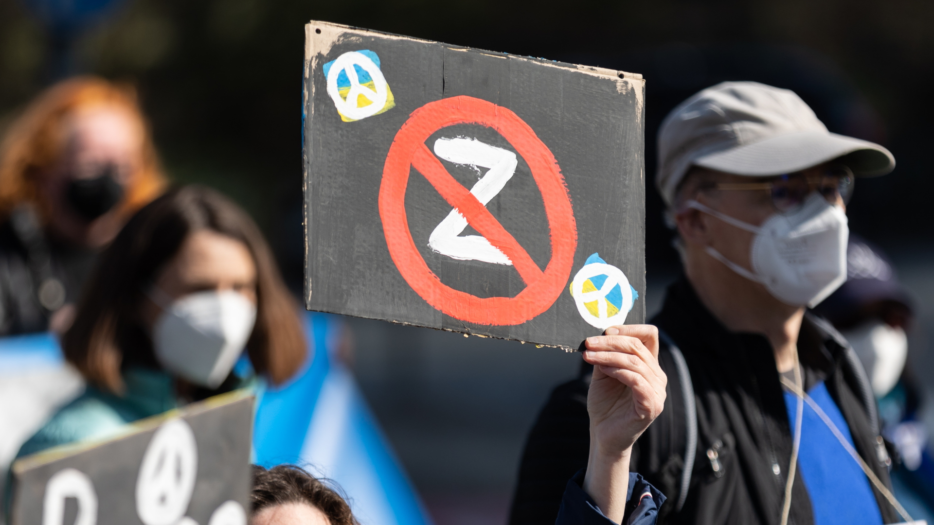 Eine Demonstrantin hält ein Plakat mit einem durchgestrichenen Z bei einer Friedensdemo hoch. | dpa