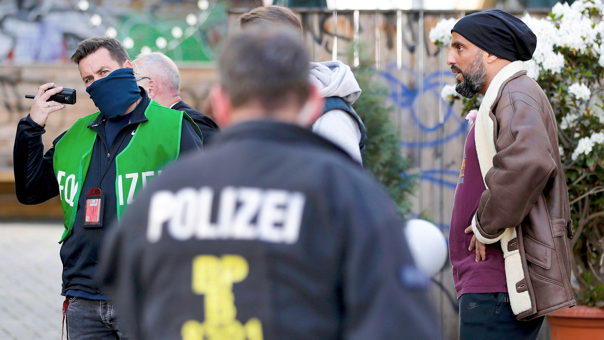 Der Komiker und Fernsehmoderator Abdelkarim, rechts, spricht mit einem Polizisten, nachdem ein Fernsehteam, zu dem er gehörte, am Freitag, dem 1. Mai 2020, in Berlin am Rande eines illegalen Protests angegriffen worden war. | AP