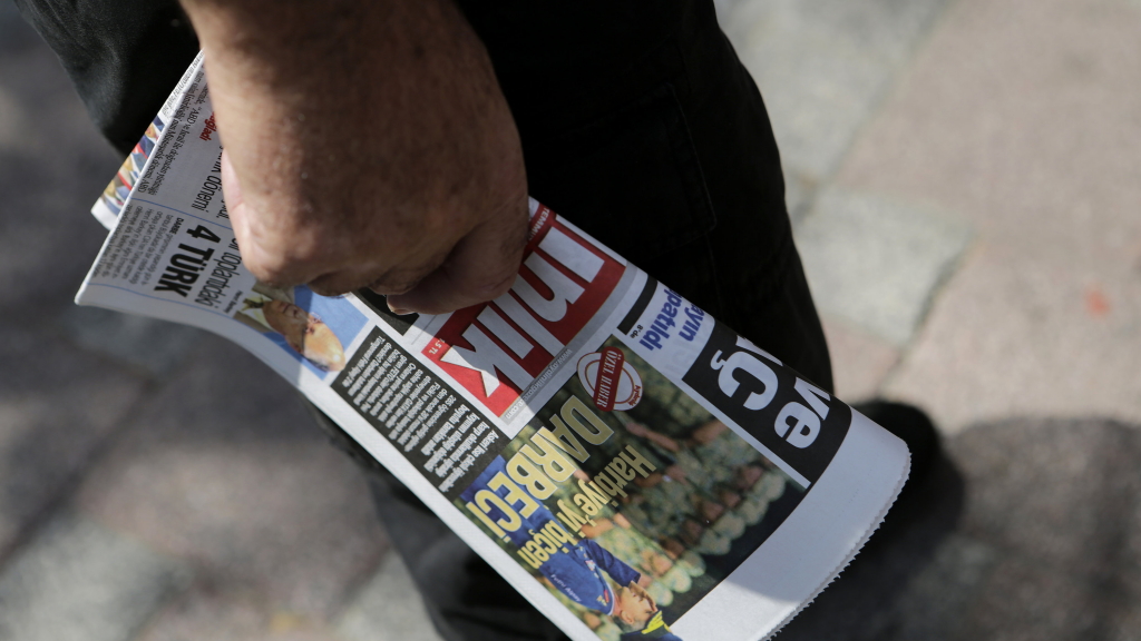 Ein Mann geht mit einer Zeitung in der Hand durch Istanbul.