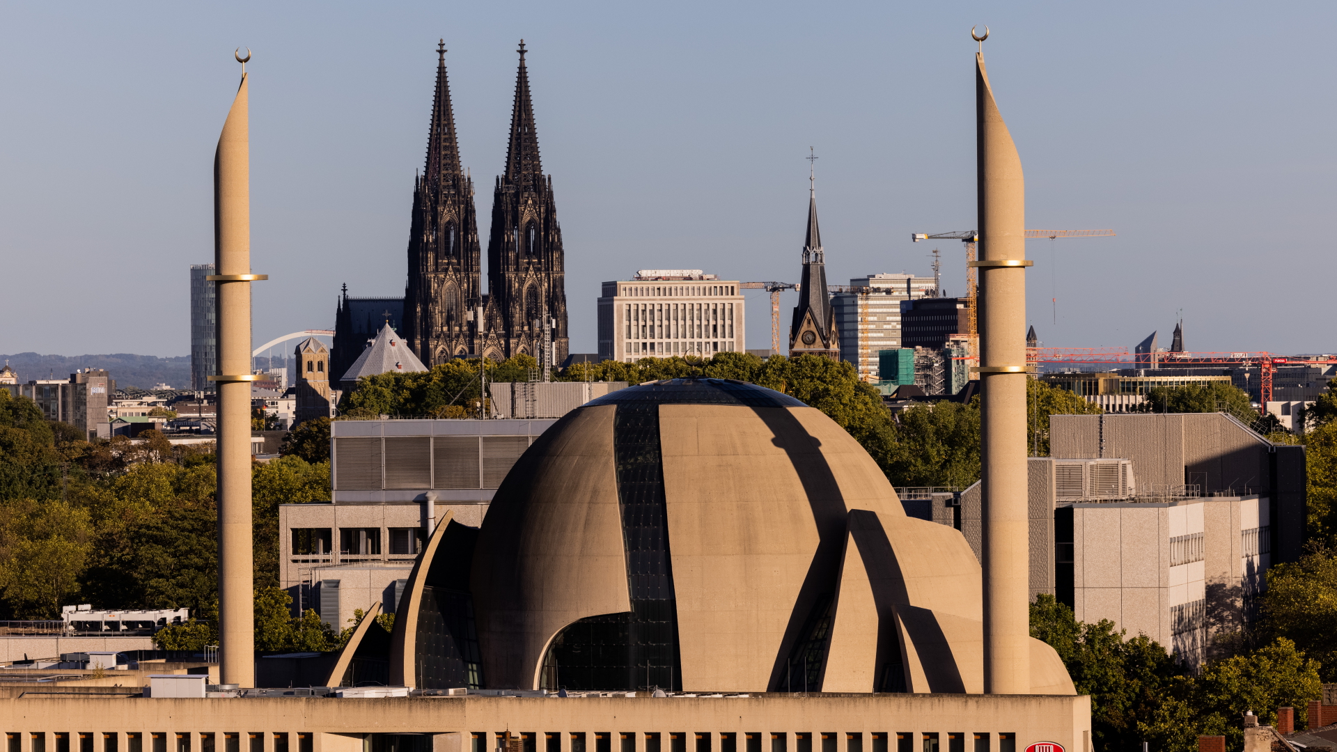 Im Licht in der untergehenden Sonne ragen die Minarette der Zentralmoschee der DITIB (Türkisch-Islamische Union der Anstalt für Religion) vor den Türmen des Kölner Doms in den Himmel.  | dpa