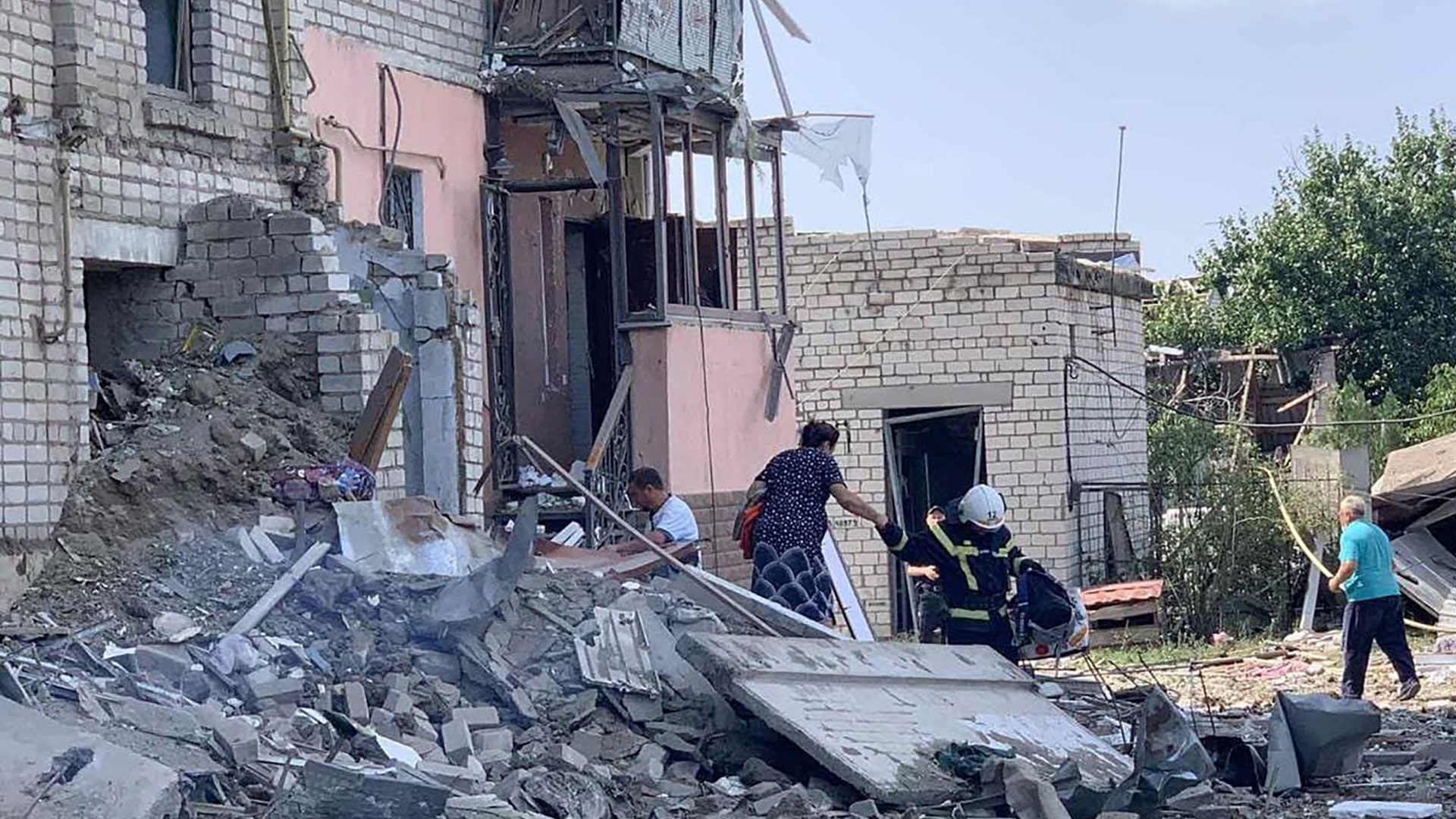 Das von ukrainischen Behörden veröffentlichte Foto zeigt Menschen vor einem zerstörten Wohnhaus in Wosnessensk. | AFP