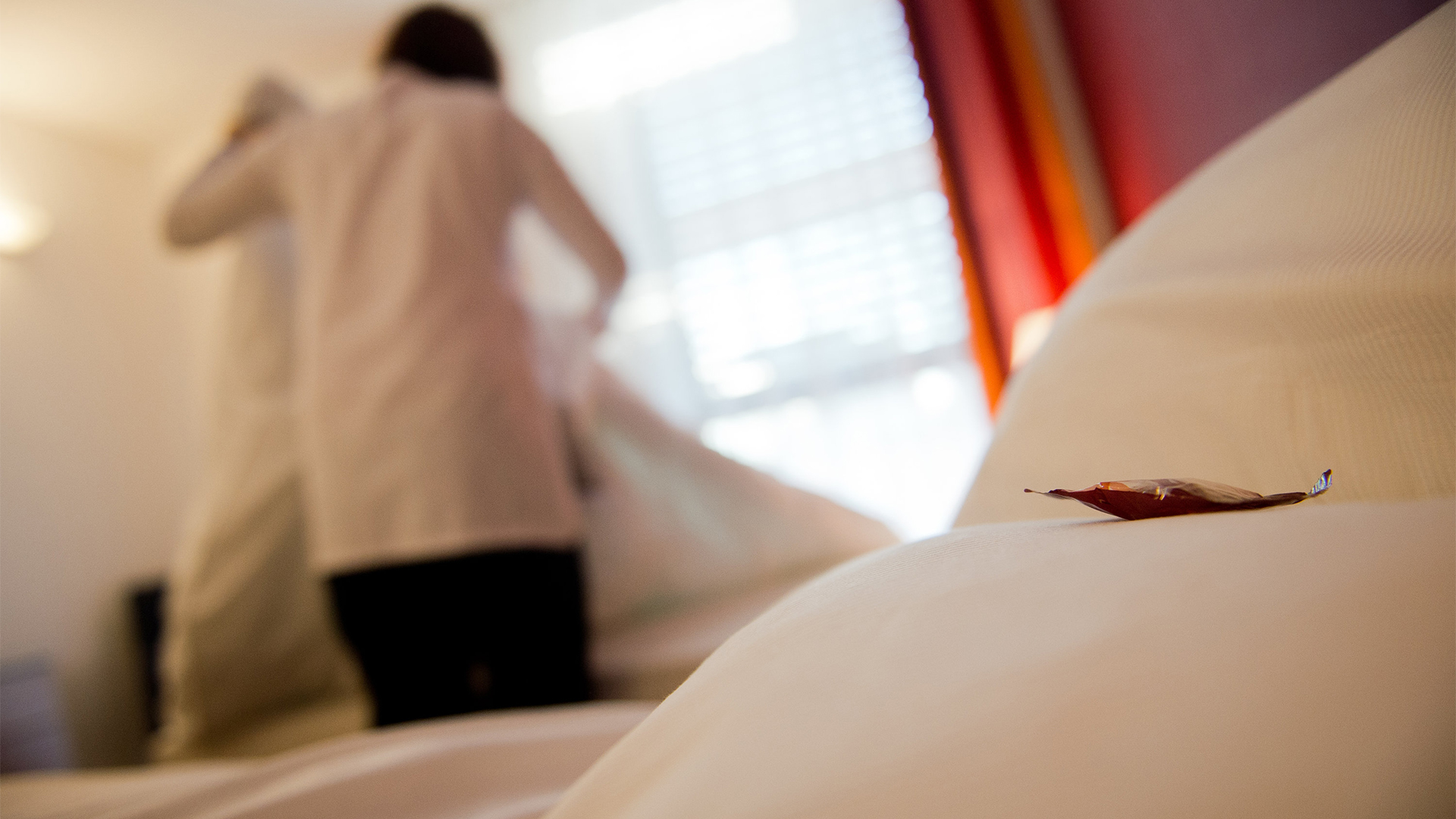 Ein Zimmermädchen richtet in einem Hotel die Betten | Bildquelle: dpa
