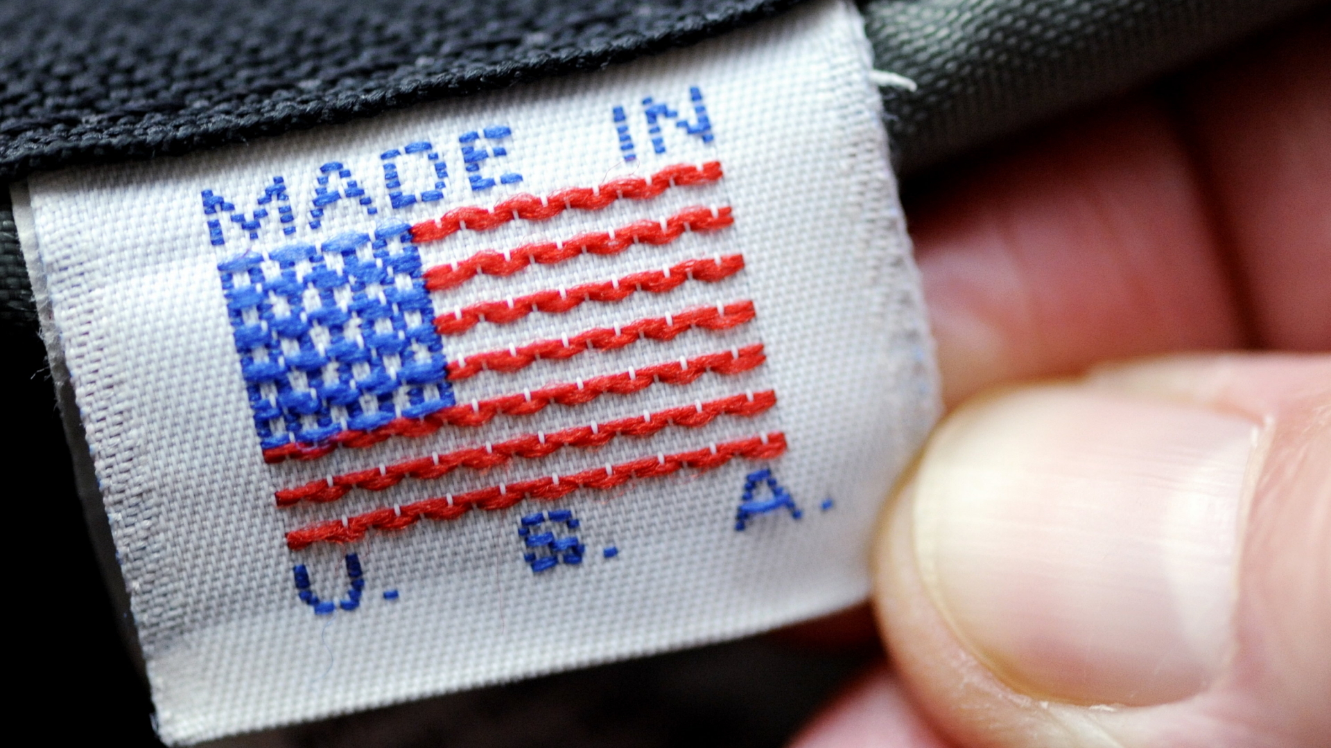 Eine Hand hält ein Etikett mit der Aufschrift "Made in U.S.A."