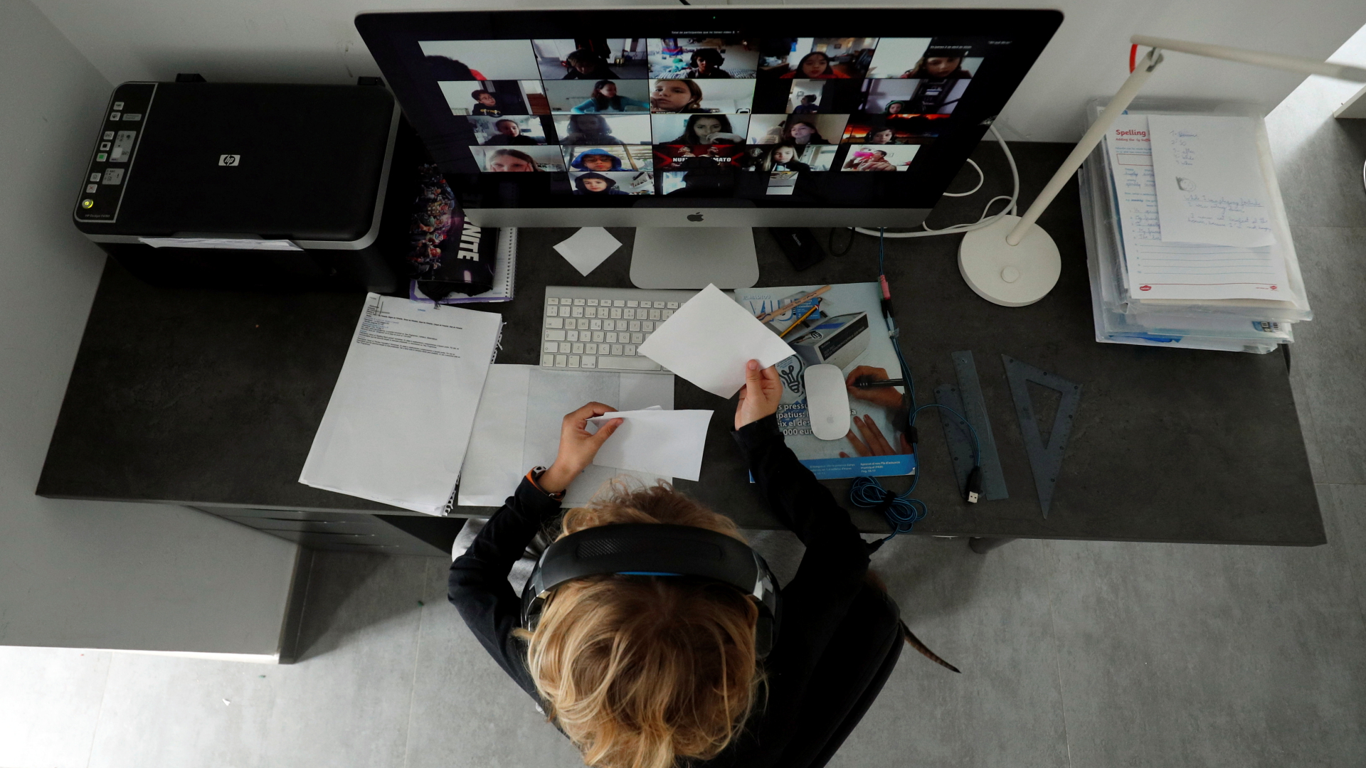 Eine Frau sitzt während einer Videokonferenz am Schreibtisch. | REUTERS