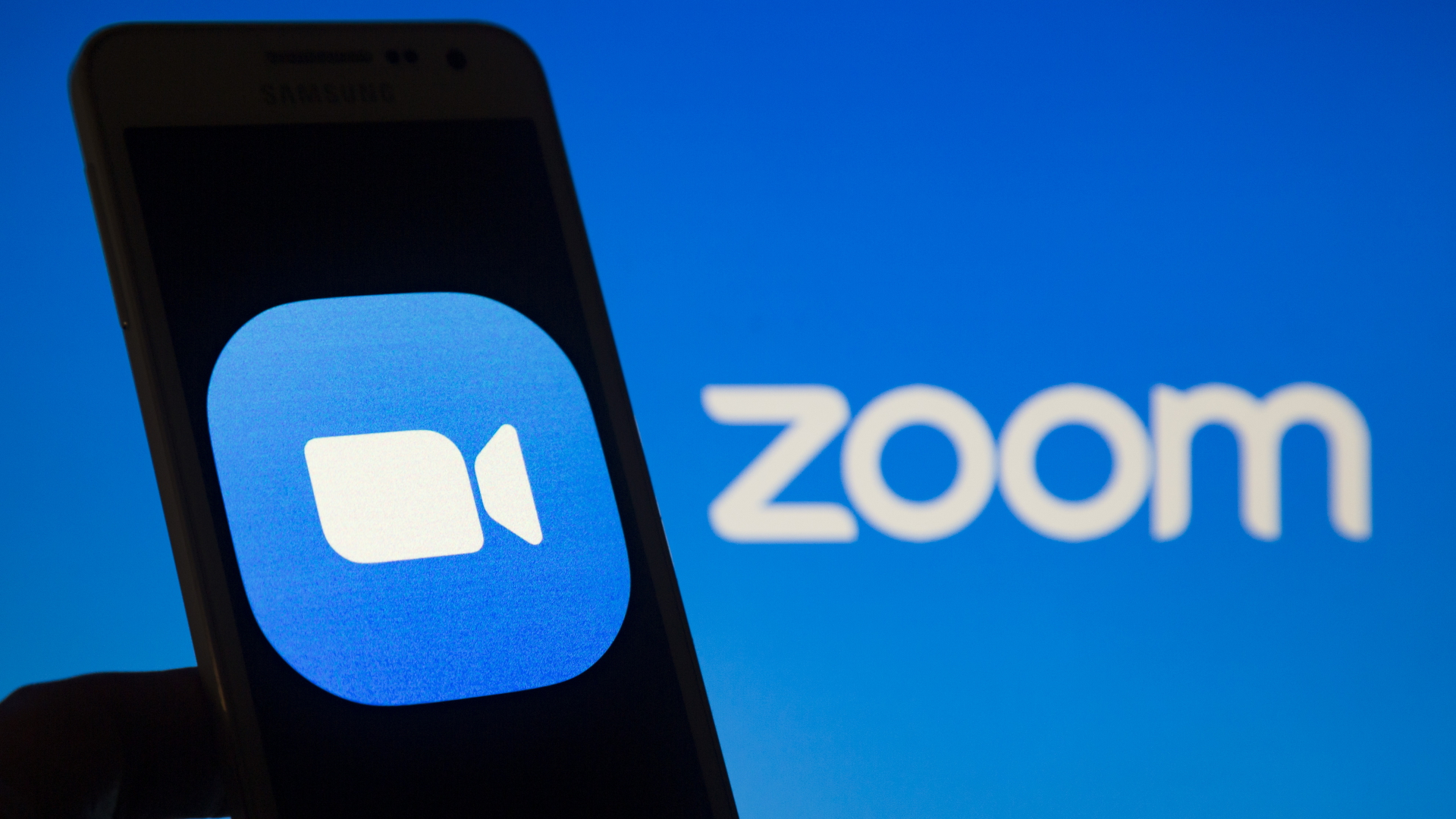 Das Logo des Videokonferenzdienstes Zoom ist auf einem Smartphone-Bildschirm zu sehen. | dpa