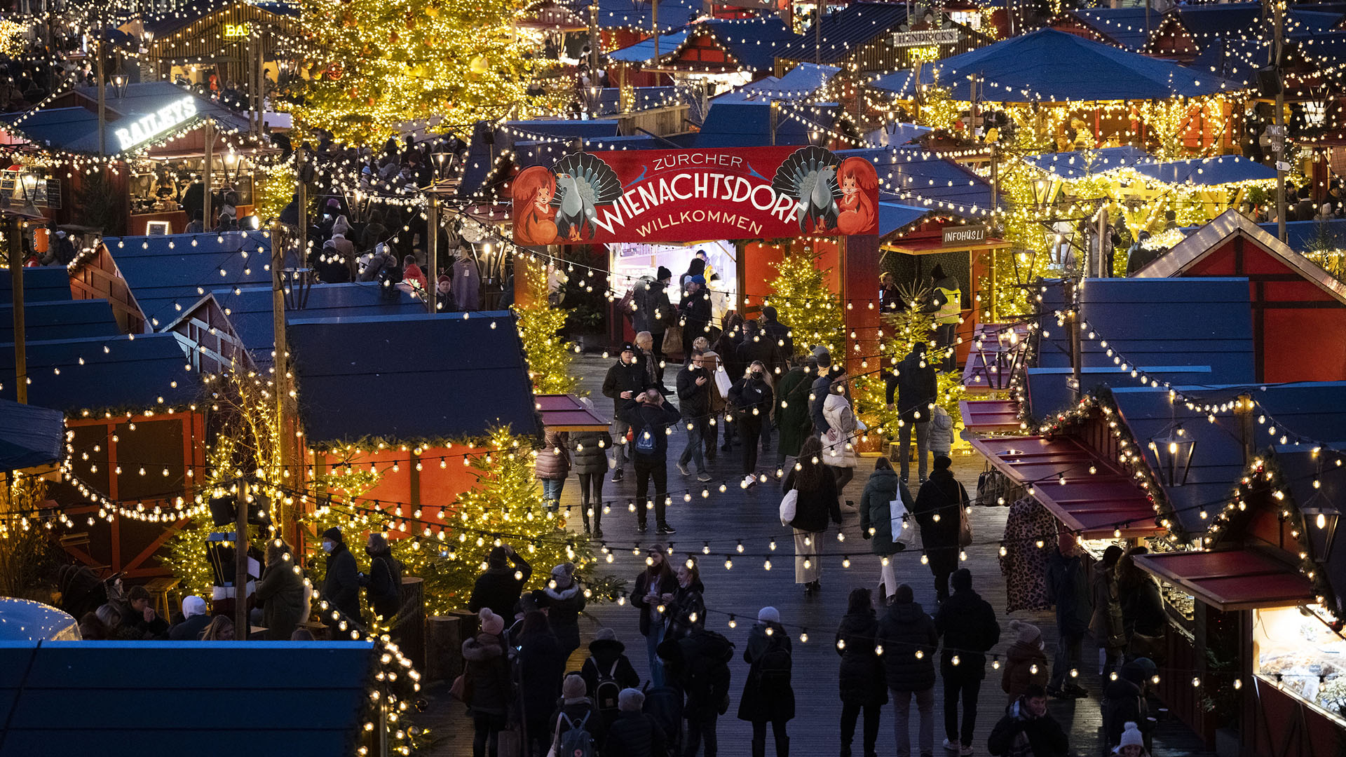 Menschen besuchen den Weihnachtsmarkt «Wienachtsdorf» auf dem Zürcher Sechseläutenplatz.  | picture alliance/dpa/KEYSTONE
