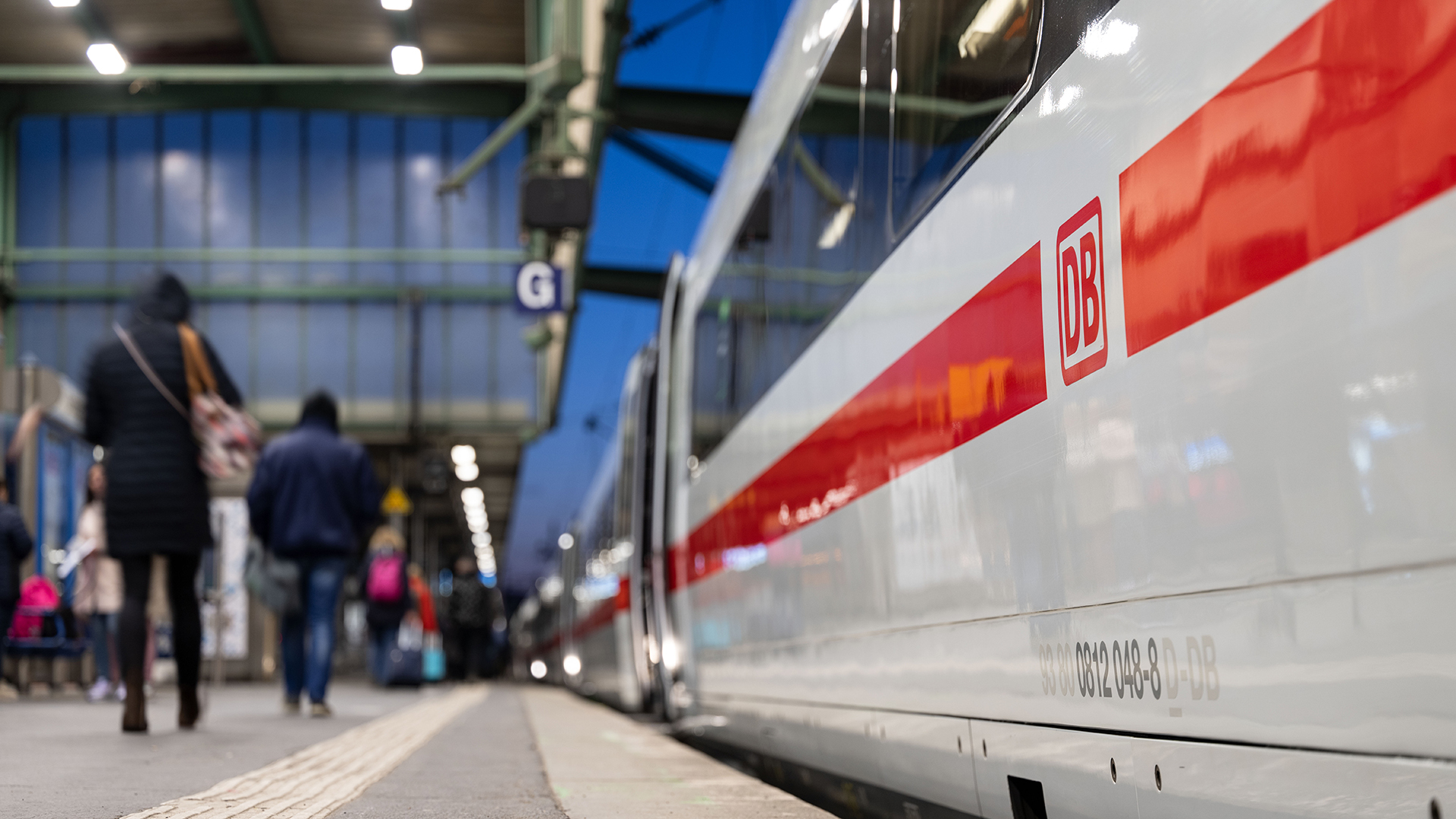Reisende gehen am Stuttgarter Hauptbahnhof an einem ICE vorbei.