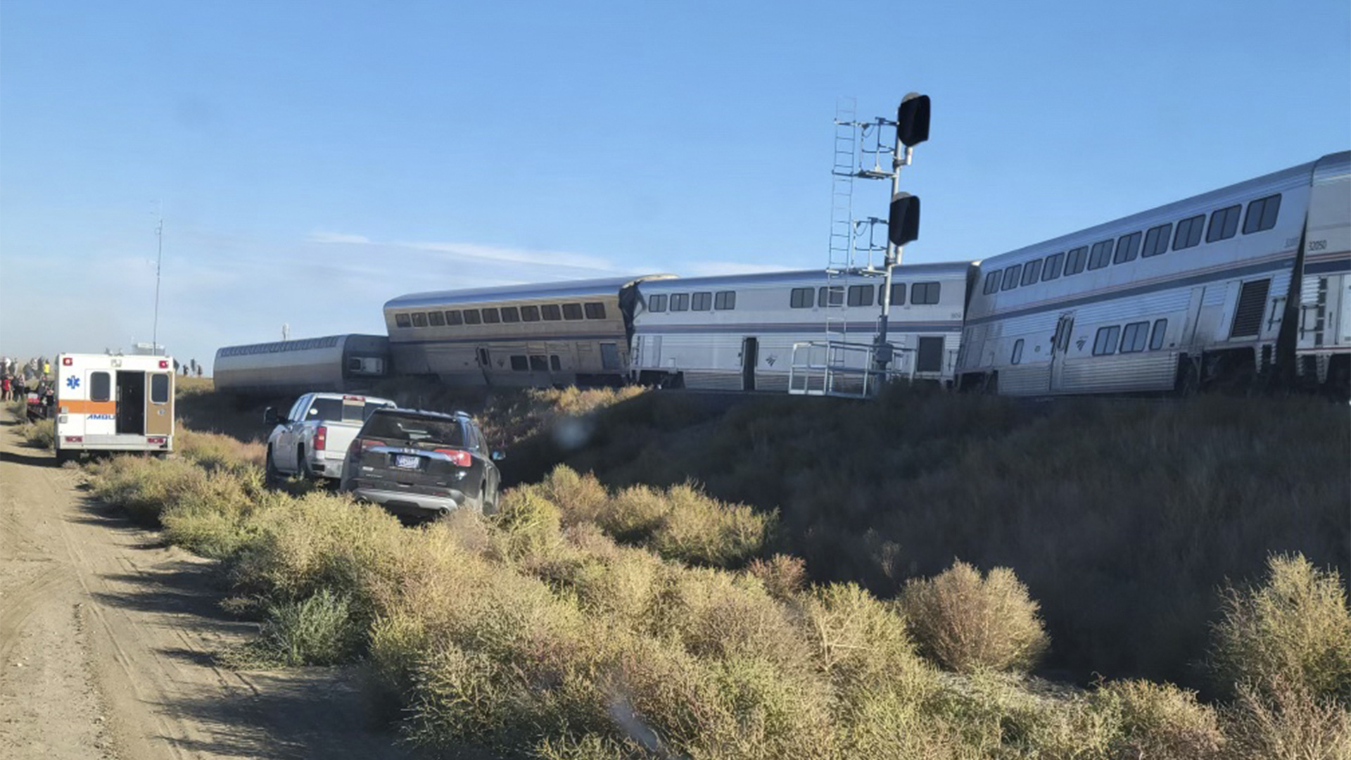 Fahrzeuge stehen neben einem entgleisten Zug. | AP