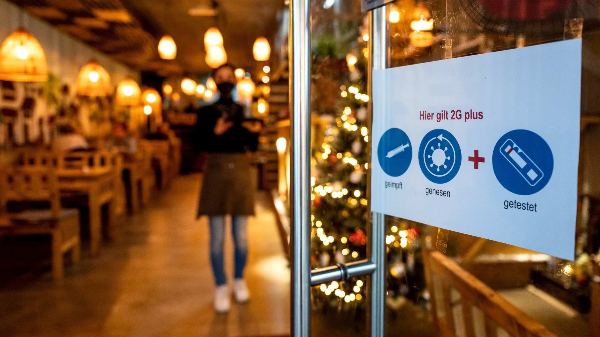 Am Eingang eines Restaurants in Oldenburg hängt ein Schild, das zur Einhaltung der 2G-plus-Regel auffordert.  | dpa