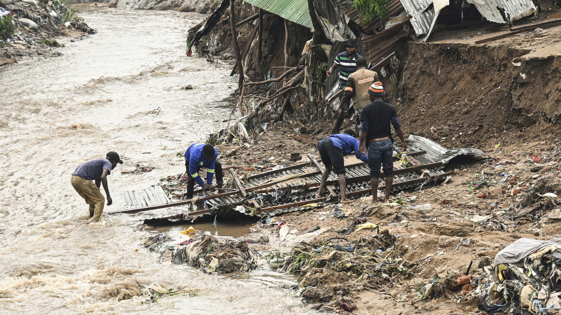 Männer bergen in Malawi Teile ihres zerstörten Hauses nach schweren Regenfällen, die der Zyklon "Freddy" verursacht hat. | dpa