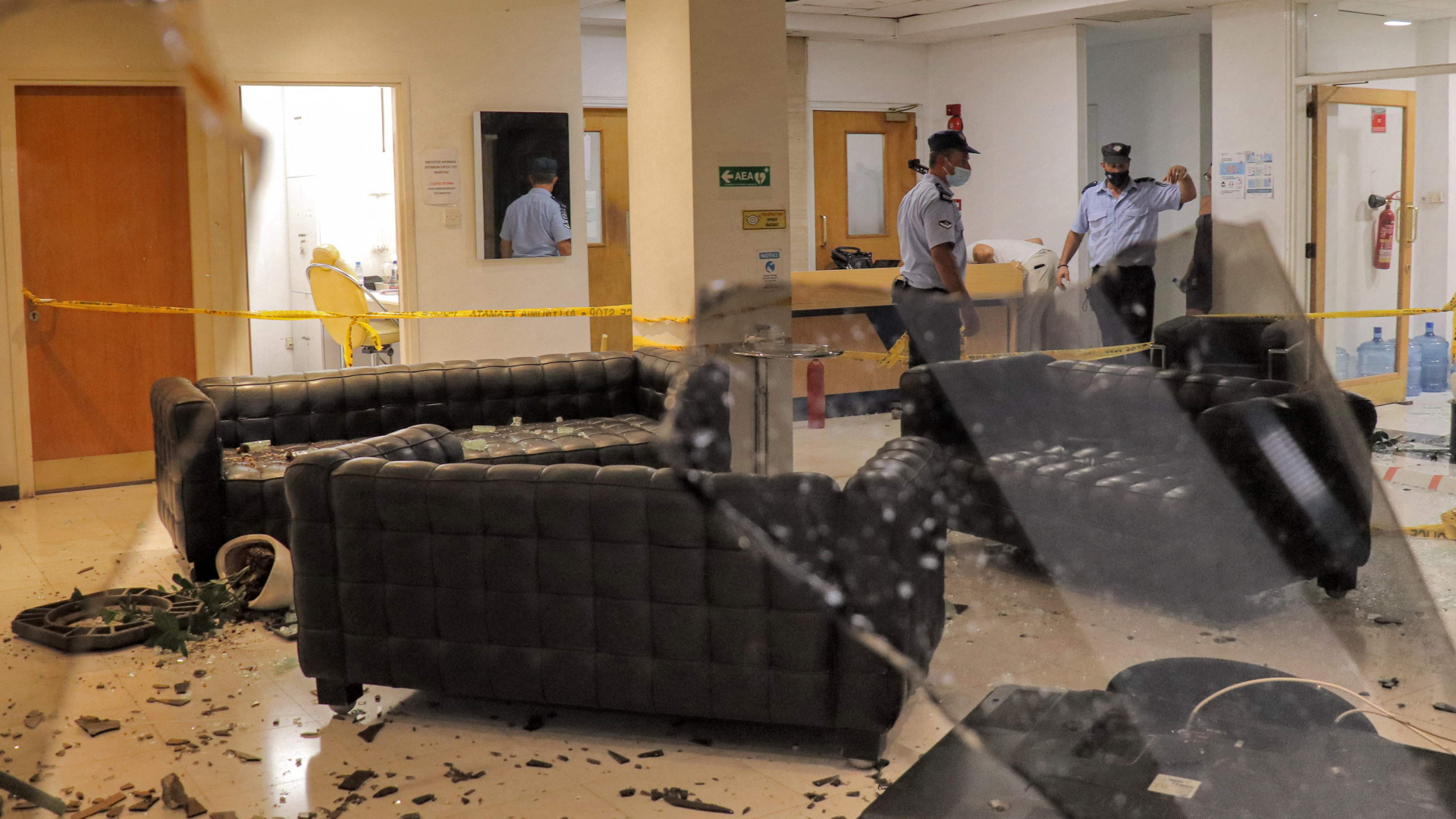 Polizisten stehen in der von Demonstranten verwüsteten Lobby des Fernsehsenders Sigma in Zypern. | AFP