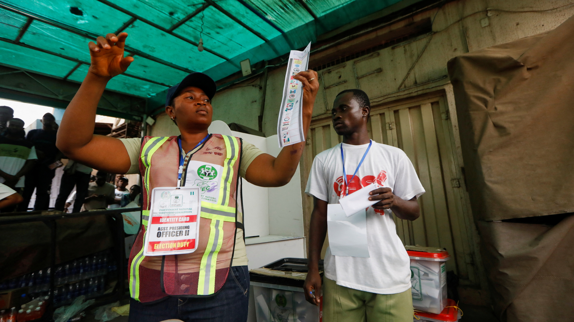 Ein Mitarbeiter eines Wahlbüros in der nigeriansichen Stadt Awka hält einen Stimmzettel hoch. | REUTERS
