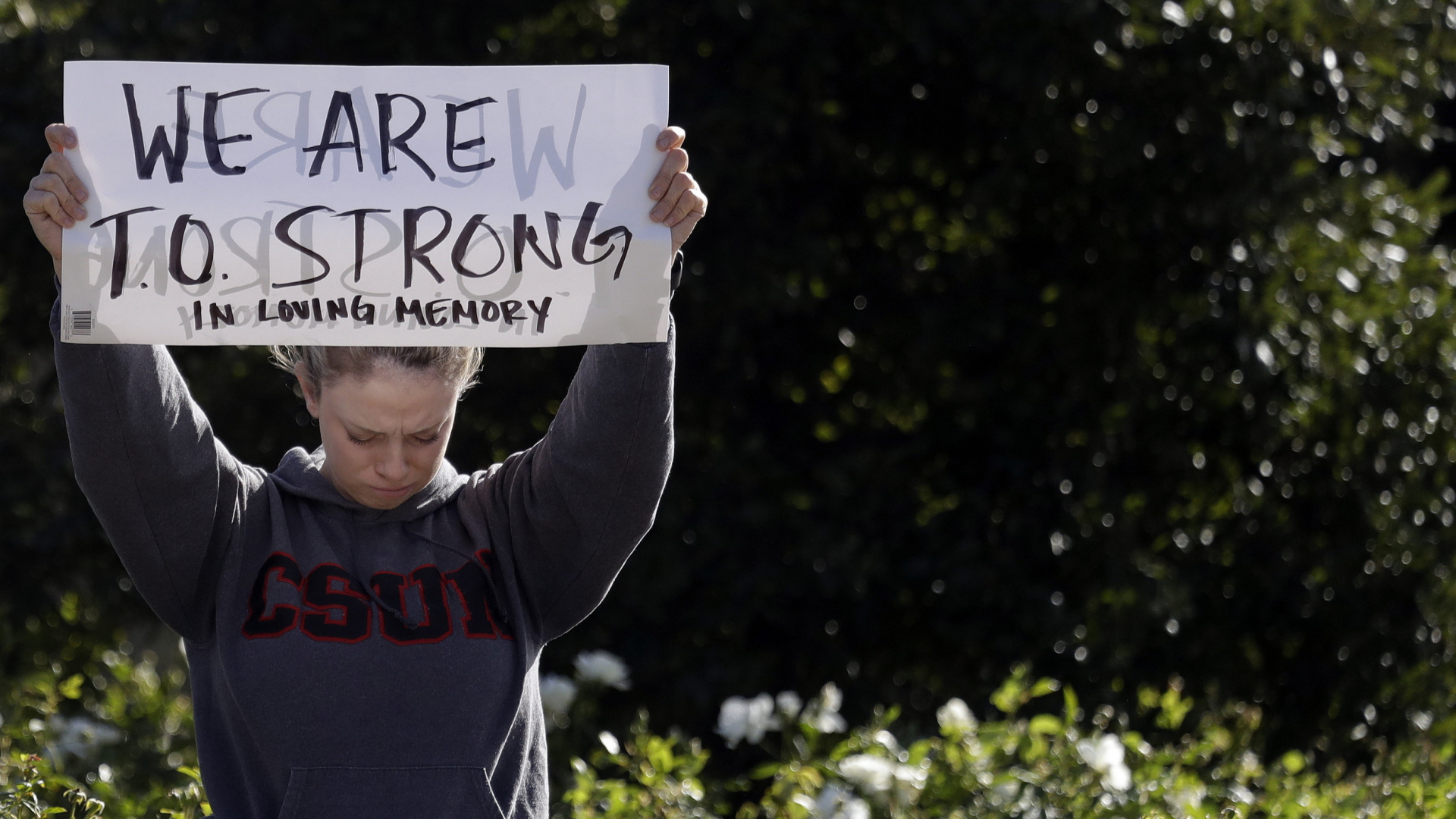 Ein junge Frau hält ein Schild mit der Aufschrift "We are T.O strong" hoch.  | Bildquelle: AP
