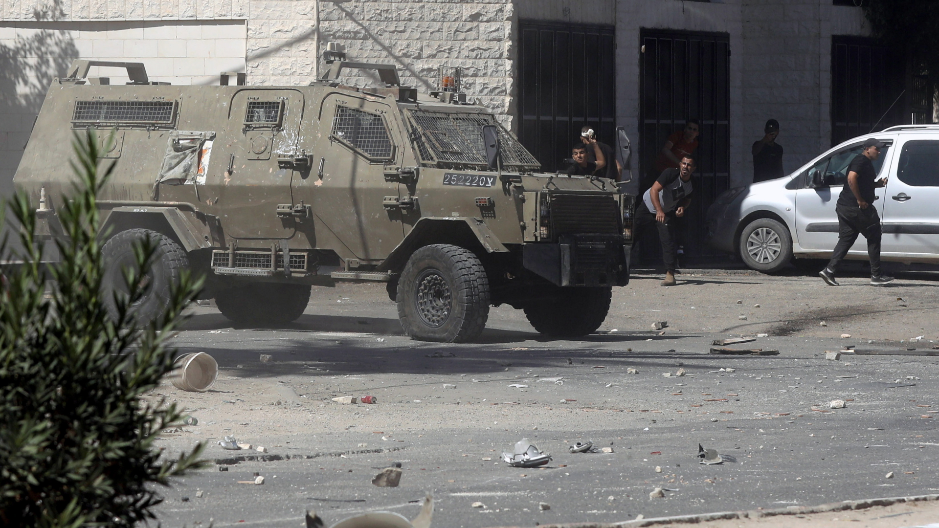 Ein gepanzertes Fahrzeug der israelischen Armee wird in Dschenin von Palästinensern mit Steinen beworfen. | EPA
