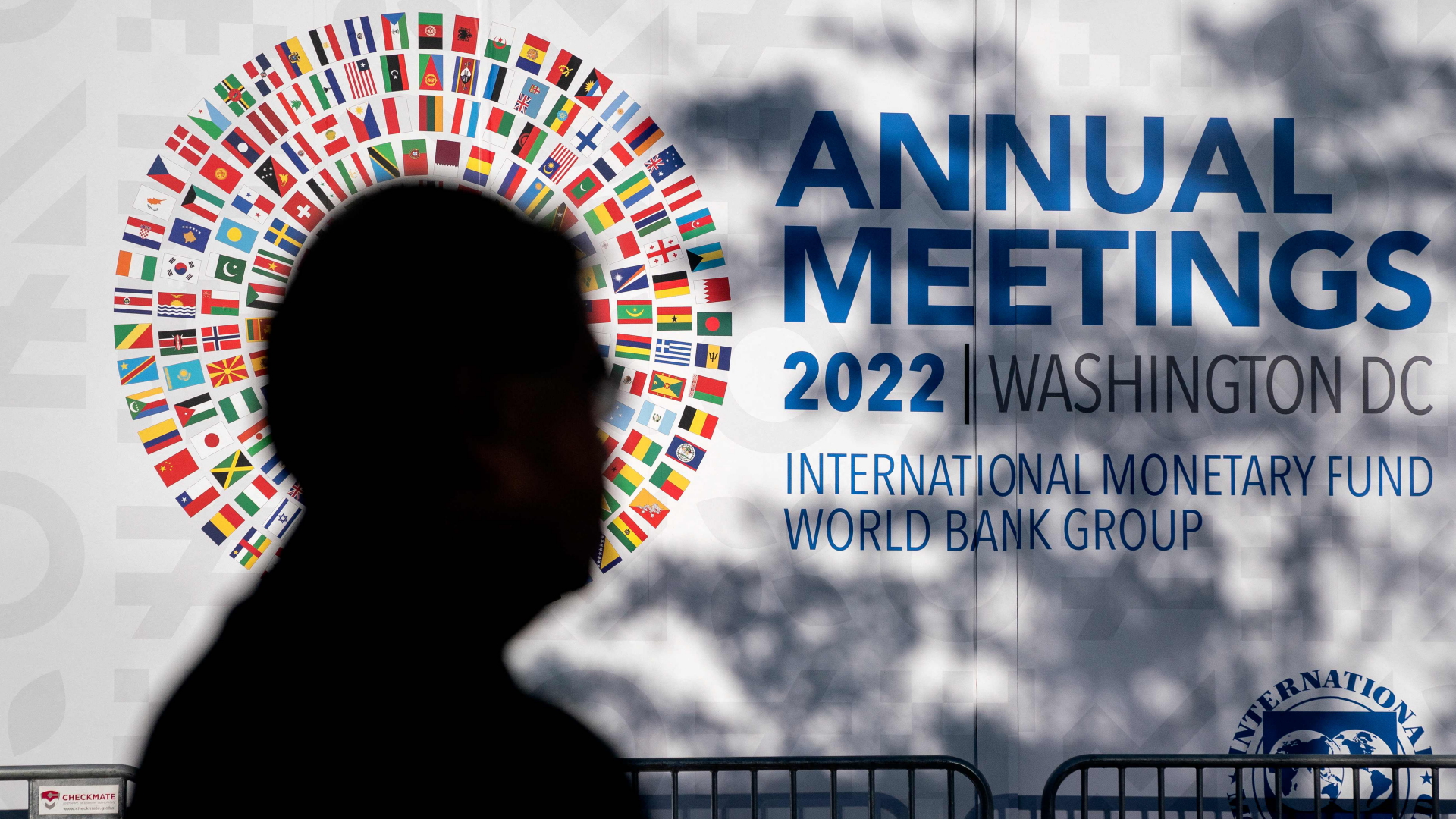 Der Schatten eines Mannes ist vor dem Logo der diesjährigen Jahrestagung von Weltbank und IWF zu sehen. | AFP