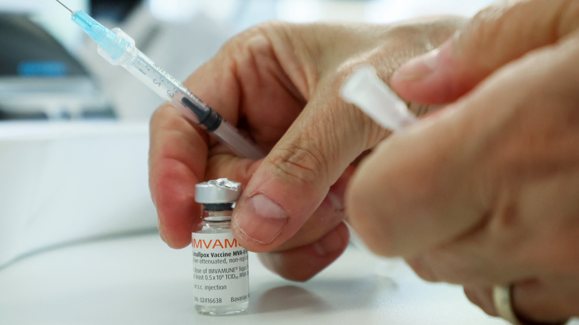 Hände mit einer Affenpocken-Impfstoffflasche und einer Spritze | REUTERS