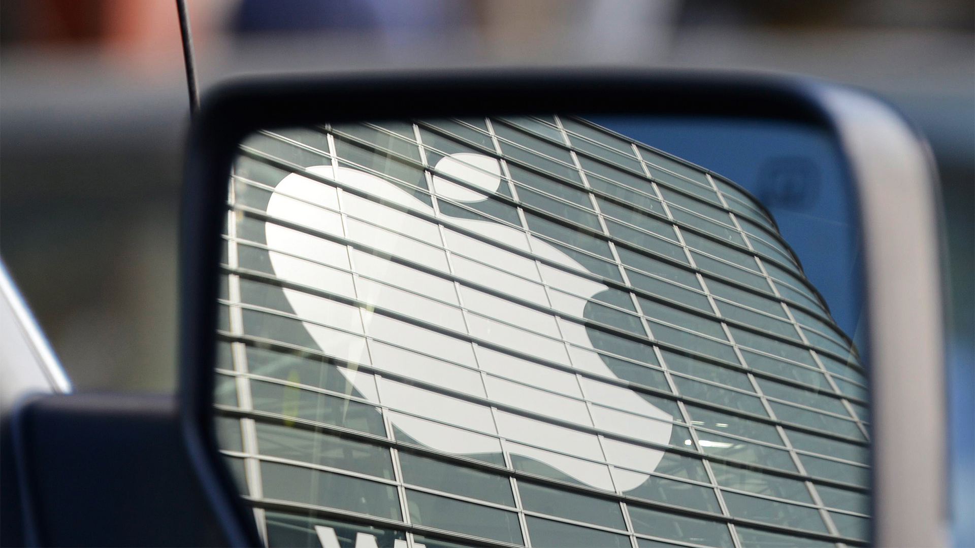 Apple Logo im Rückspiegel eines Autos. | picture alliance / John G. Maban