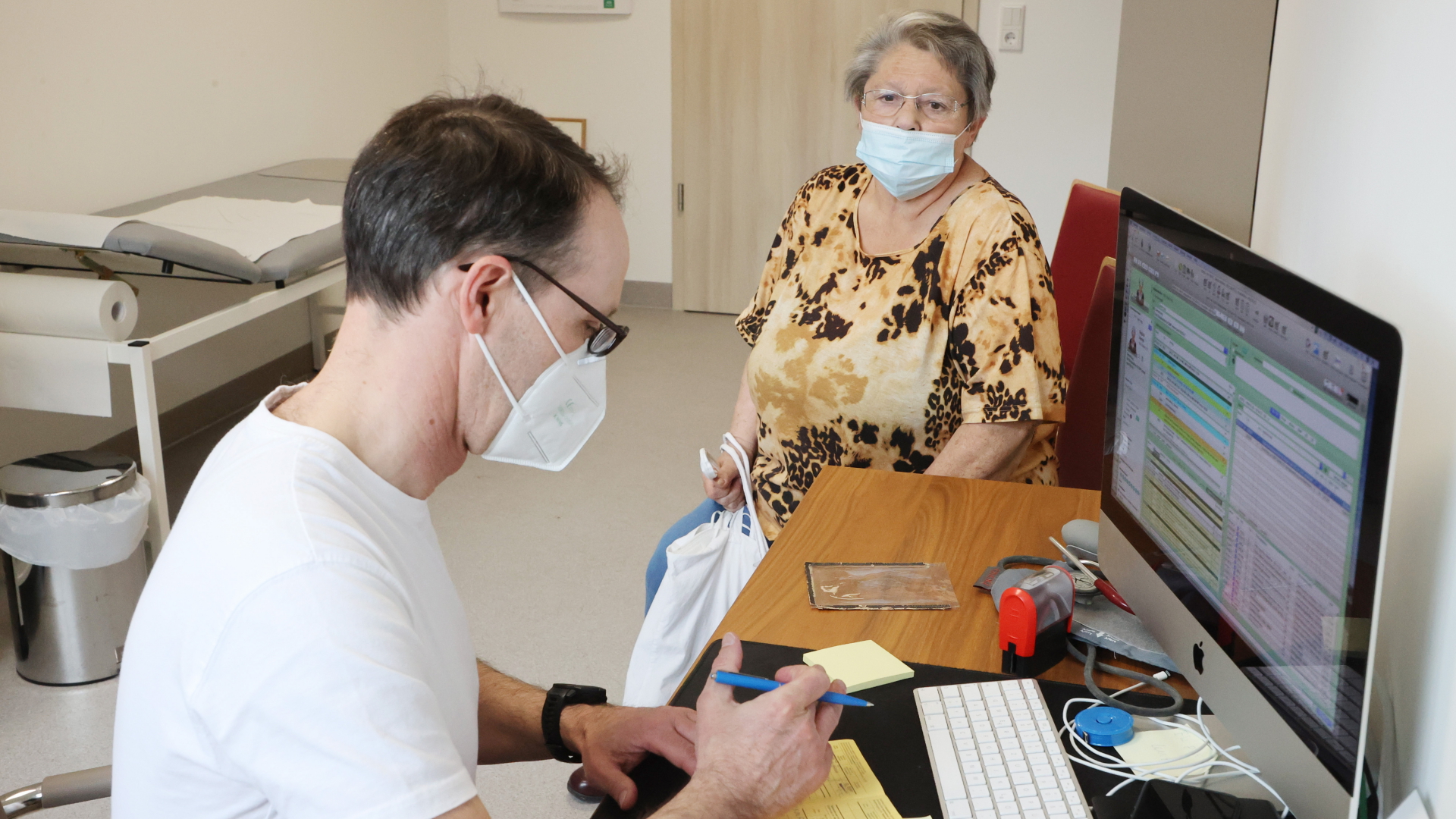 Ein Hausarzt spricht mit einer Patientin in seiner Praxis in Thüringen. | dpa
