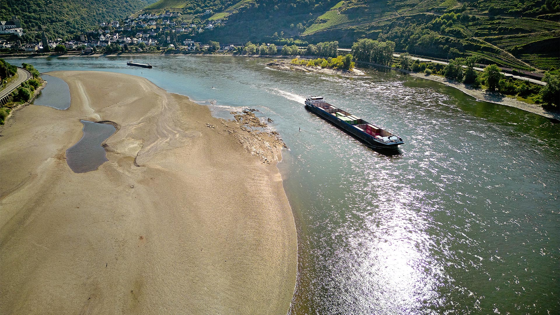 Anhaltende Trockenheit: Ein Frachtschiff passiert auf dem Rhein eine Sandbank. | picture alliance/dpa