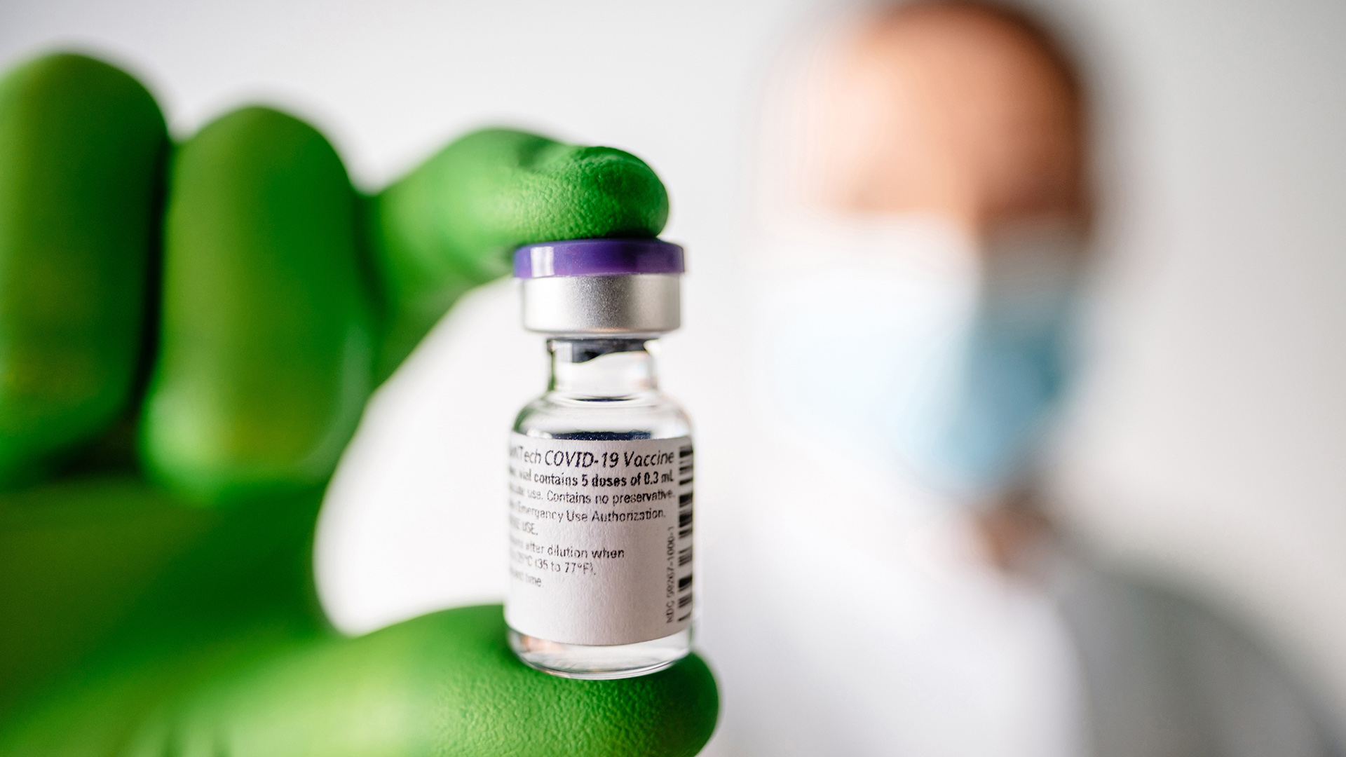 Rheinland-Pfalz, Mainz: Ein Mitarbeiter des Unternehmens Biontech hält ein Fläschen mit Corona-Impfstoff in der Hand. | dpa