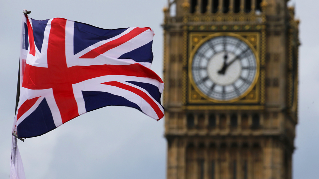 Eine britische Fahne weht in London vor dem Uhrturm Big Ben.