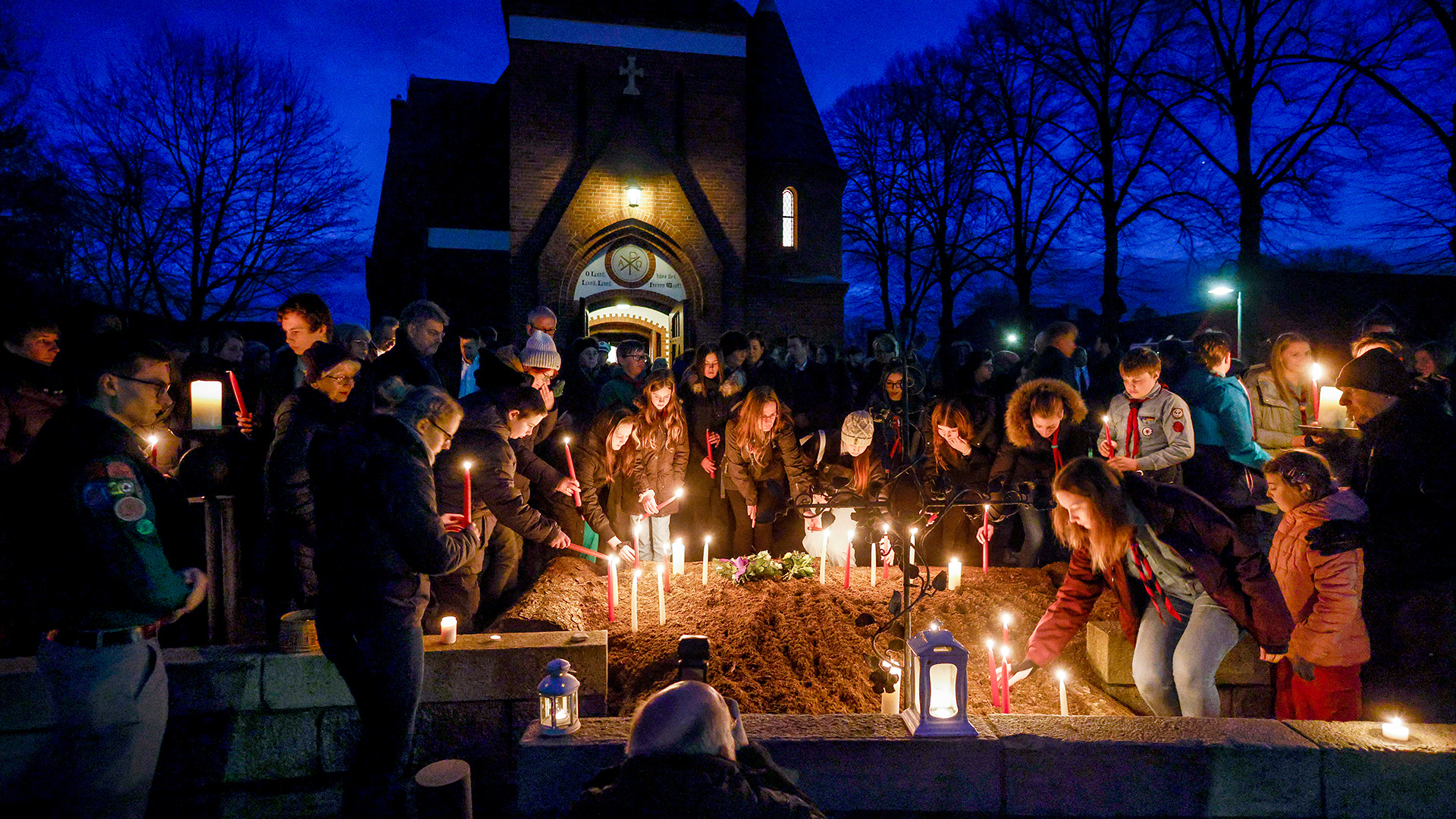 Teilnehmer der Andacht der Evangelisch-Lutherischen Kirchengemeinde Brokstedt für die Opfer des Messerangriffs stellen nach dem Gottesdienst Kerzen vor der Kirche auf.  | dpa