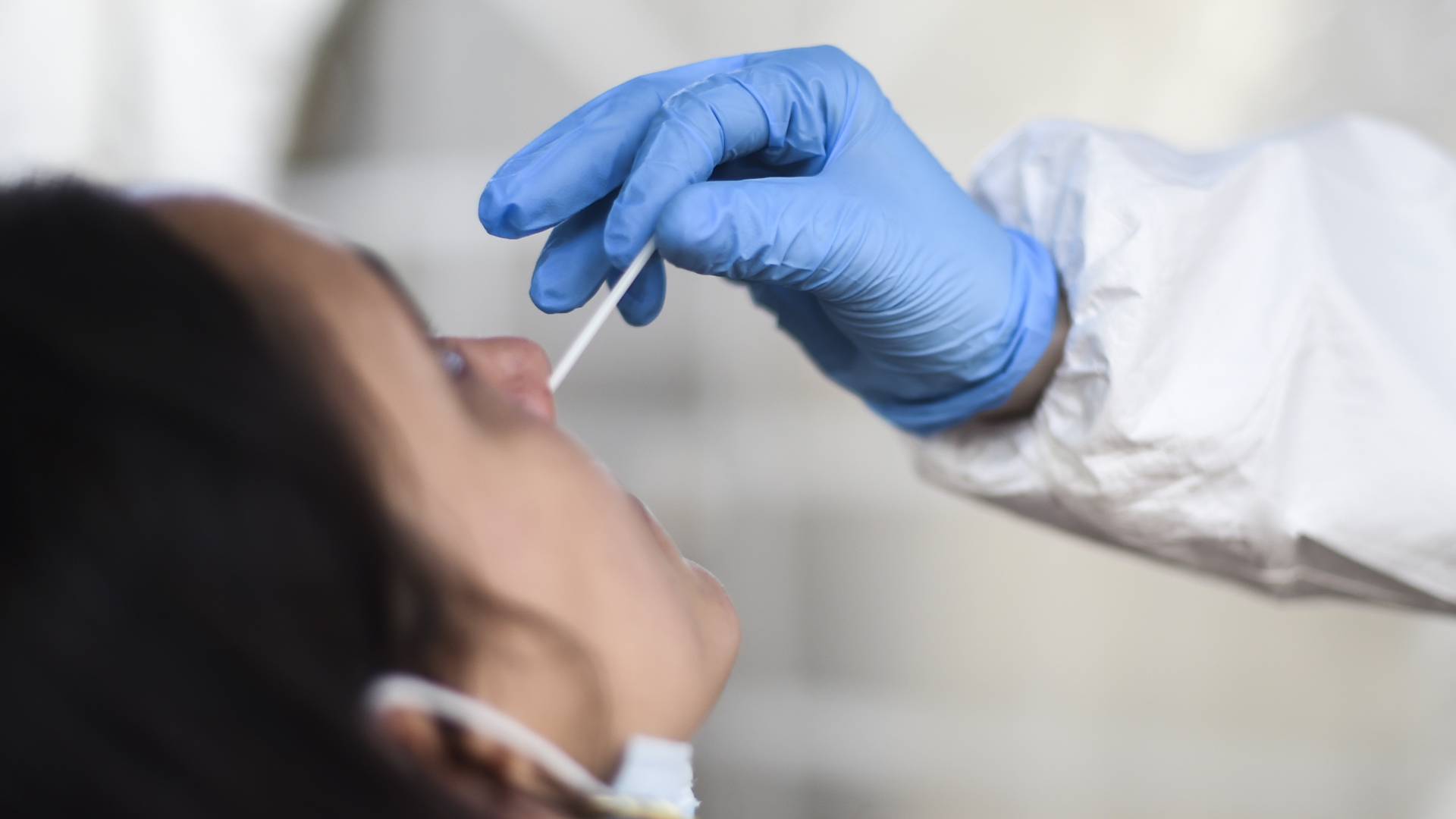Eine Mitarbeiterin eines Testzentrums nimmt einen Nasenabstrich für einen Corona-Schnelltest.  | dpa