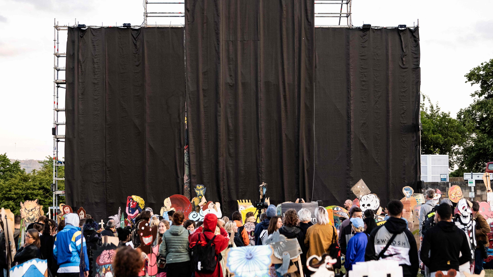 Menschen stehen vor dem abgehängten umstrittenen Banner auf der documenta in Kassel  | AFP